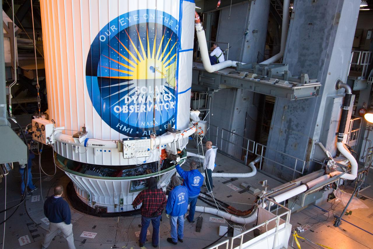 CAPE CANAVERAL, Fla. – In the Vertical Integration Facility at Launch Complex 41 on Cape Canaveral Air Force Station, workers prepare to secure the payload fairing enclosing NASA's Solar Dynamics Observatory, or SDO, to the Atlas V rocket.  SDO is the first mission in NASA's Living With a Star Program and is designed to study the causes of solar variability and its impacts on Earth. The spacecraft's long-term measurements will give solar scientists in-depth information to help characterize the interior of the Sun, the Sun's magnetic field, the hot plasma of the solar corona, and the density of radiation that creates the ionosphere of the planets. The information will be used to create better forecasts of space weather needed to protect the aircraft, satellites and astronauts living and working in space. Liftoff is targeted for Feb. 9. For information on SDO, visit http:__www.nasa.gov_sdo.  Photo credit: NASA_Jack Pfaller