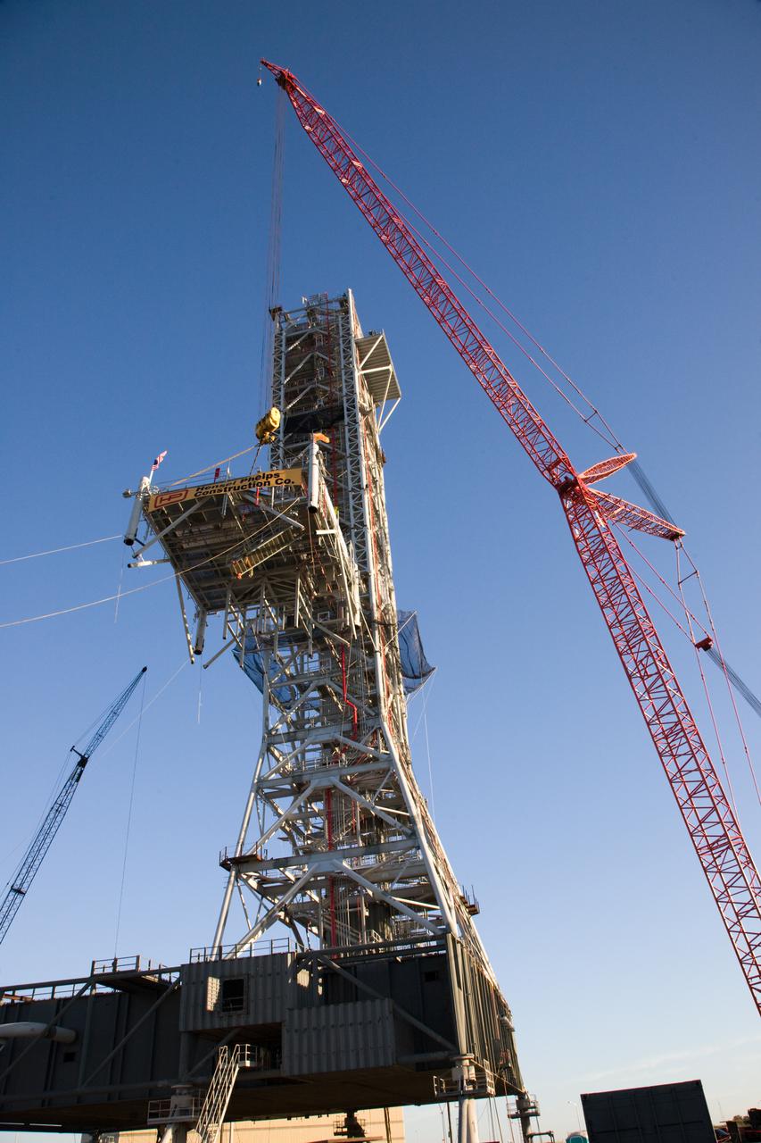 CAPE CANAVERAL, Fla. – At NASA’s Kennedy Space Center in Florida, a large crane lifts the tenth and final tower segment of a new mobile launcher, or ML, being constructed to support the Constellation Program, to the top of the growing tower. When completed, the tower will be approximately 345 feet tall and have multiple platforms for personnel access. Its base is being made lighter than space shuttle mobile launcher platforms so the crawler-transporter can pick up the heavier load of the tower and a taller rocket.  For information on the Constellation Program, visit http:__www.nasa.gov_constellation. Photo credit: NASA_Amanda Diller