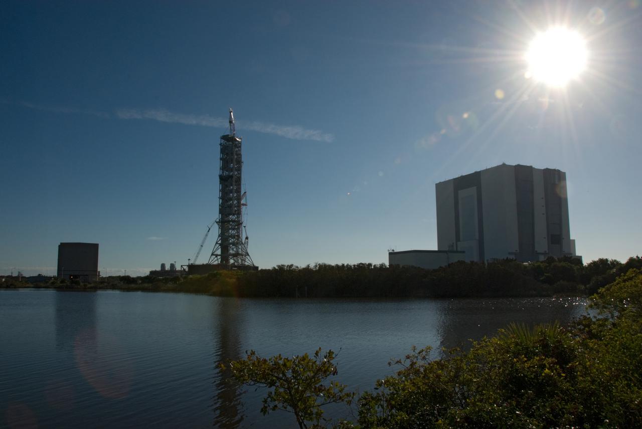 CAPE CANAVERAL, Fla. – At NASA’s Kennedy Space Center in Florida, the sun shines brightly over the Vehicle Assembly Building as a large crane lowers the tenth and final segment of a new mobile launcher, or ML, being constructed to support the Constellation Program, onto the top of the tower. When completed, the tower will be approximately 345 feet tall and have multiple platforms for personnel access. Its base is being made lighter than space shuttle mobile launcher platforms so the crawler-transporter can pick up the heavier load of the tower and a taller rocket.  For information on the Constellation Program, visit http:__www.nasa.gov_constellation. Photo credit: NASA_Kim Shiflett