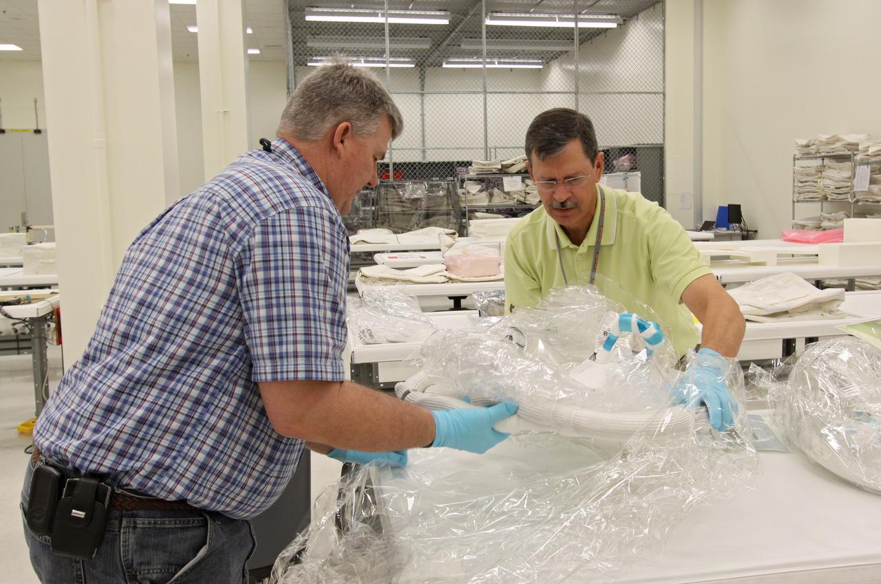 CAPE CANAVERAL, Fla. – In the Space Station Processing Facility at NASA's Kennedy Space Center in Florida, workers unwrap the newly arrived replacement high-pressure ammonia jumper hoses to support space shuttle Endeavour's STS-130 mission.  A problem arose during a prelaunch test Jan. 7 with one of four hoses that are needed to connect the ammonia loops of the International Space Station's Tranquility node to those of the Destiny laboratory.  A decision was made to use an alternate hose design for use as the primary jumper.  The new hoses are assembled from shorter hoses that were previously certified and tested.  Connection of the modules requires two ammonia loops, with two lines apiece, each of which must be connected to both Tranquility and Destiny to route cooling to and from the Tranquility module.  The primary payload for the STS-130 mission, Tranquility is a pressurized module that will provide additional room for crew members and many of the station's life support and environmental control systems. The node was built in Turin, Italy, by Thales Alenia Space for the European Space Agency.  Endeavour's launch is set for Feb. 7.  For information on the STS-130 mission and crew, visit http:__www.nasa.gov_mission_pages_shuttle_shuttlemissions_sts130_index.html.  Photo credit: NASA_Jack Pfaller
