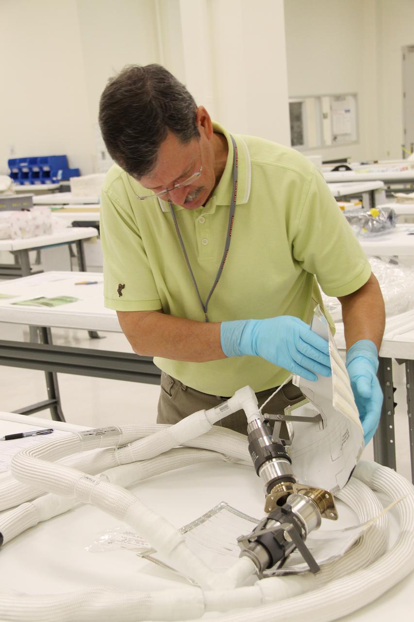 CAPE CANAVERAL, Fla. – In the Space Station Processing Facility at NASA's Kennedy Space Center in Florida, workers unwrap the newly arrived replacement high-pressure ammonia jumper hoses to support space shuttle Endeavour's STS-130 mission.  A problem arose during a prelaunch test Jan. 7 with one of four hoses that are needed to connect the ammonia loops of the International Space Station's Tranquility node to those of the Destiny laboratory.  A decision was made to use an alternate hose design for use as the primary jumper.  The new hoses are assembled from shorter hoses that were previously certified and tested.  Connection of the modules requires two ammonia loops, with two lines apiece, each of which must be connected to both Tranquility and Destiny to route cooling to and from the Tranquility module.  The primary payload for the STS-130 mission, Tranquility is a pressurized module that will provide additional room for crew members and many of the station's life support and environmental control systems. The node was built in Turin, Italy, by Thales Alenia Space for the European Space Agency.  Endeavour's launch is set for Feb. 7.  For information on the STS-130 mission and crew, visit http:__www.nasa.gov_mission_pages_shuttle_shuttlemissions_sts130_index.html.  Photo credit: NASA_Jack Pfaller