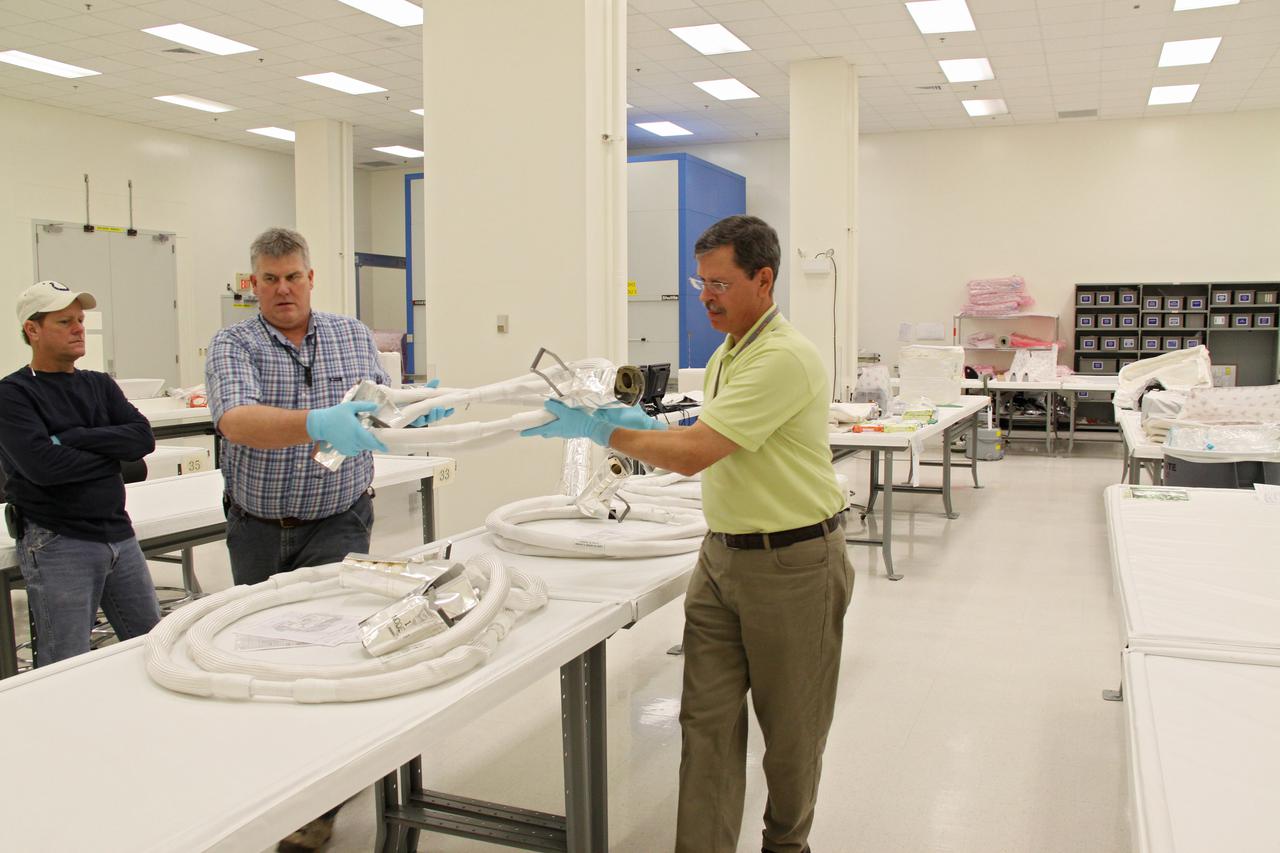 CAPE CANAVERAL, Fla. – In the Space Station Processing Facility at NASA's Kennedy Space Center in Florida, workers position along work tables the newly arrived replacement high-pressure ammonia jumper hoses to support space shuttle Endeavour's STS-130 mission.  A problem arose during a prelaunch test Jan. 7 with one of four hoses that are needed to connect the ammonia loops of the International Space Station's Tranquility node to those of the Destiny laboratory.  A decision was made to use an alternate hose design for use as the primary jumper.  The new hoses are assembled from shorter hoses that were previously certified and tested.  Connection of the modules requires two ammonia loops, with two lines apiece, each of which must be connected to both Tranquility and Destiny to route cooling to and from the Tranquility module.  The primary payload for the STS-130 mission, Tranquility is a pressurized module that will provide additional room for crew members and many of the station's life support and environmental control systems. The node was built in Turin, Italy, by Thales Alenia Space for the European Space Agency.  Endeavour's launch is set for Feb. 7.  For information on the STS-130 mission and crew, visit http:__www.nasa.gov_mission_pages_shuttle_shuttlemissions_sts130_index.html.  Photo credit: NASA_Jack Pfaller