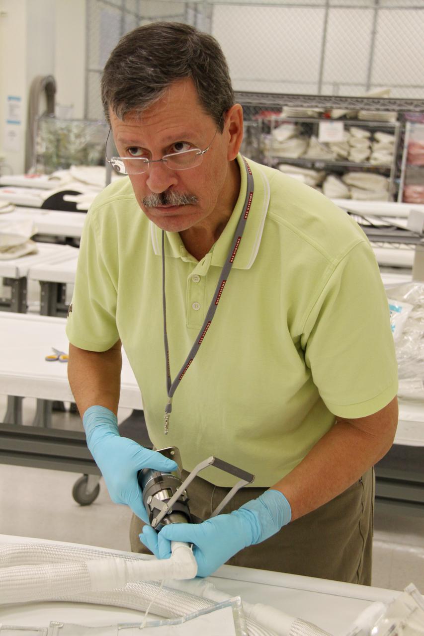 CAPE CANAVERAL, Fla. – In the Space Station Processing Facility at NASA's Kennedy Space Center in Florida, a worker inspects a newly arrived replacement high-pressure ammonia jumper hose to support space shuttle Endeavour's STS-130 mission.  A problem arose during a prelaunch test Jan. 7 with one of four hoses that are needed to connect the ammonia loops of the International Space Station's Tranquility node to those of the Destiny laboratory.  A decision was made to use an alternate hose design for use as the primary jumper.  The new hoses are assembled from shorter hoses that were previously certified and tested.  Connection of the modules requires two ammonia loops, with two lines apiece, each of which must be connected to both Tranquility and Destiny to route cooling to and from the Tranquility module.  The primary payload for the STS-130 mission, Tranquility is a pressurized module that will provide additional room for crew members and many of the station's life support and environmental control systems. The node was built in Turin, Italy, by Thales Alenia Space for the European Space Agency.  Endeavour's launch is set for Feb. 7.  For information on the STS-130 mission and crew, visit http:__www.nasa.gov_mission_pages_shuttle_shuttlemissions_sts130_index.html.  Photo credit: NASA_Jack Pfaller
