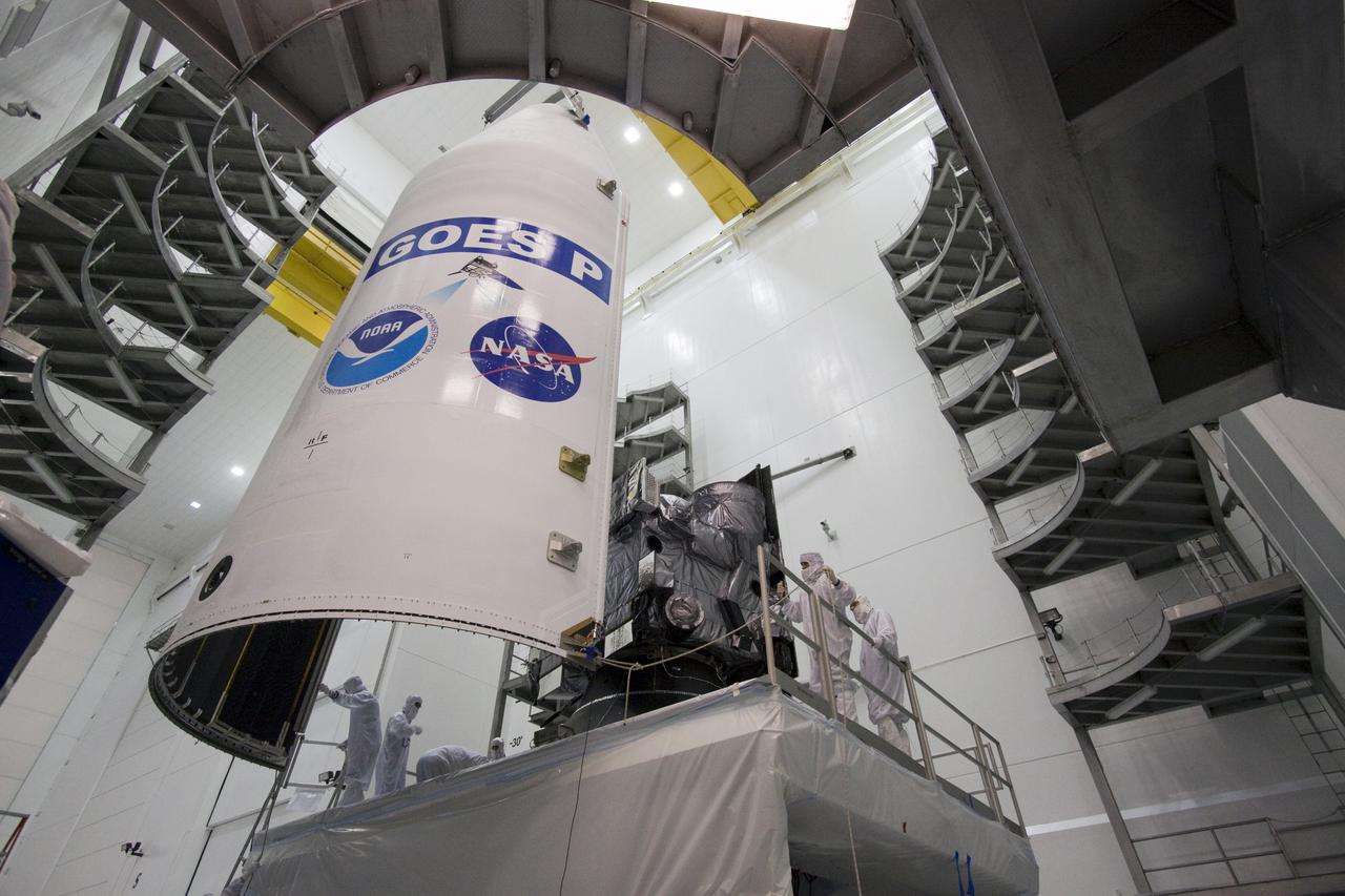 CAPE CANAVERAL, Fla. – At the Astrotech Space Operations facility in Titusville, Fla., spacecraft technicians guide one side of the Delta IV payload fairing that will enclose NASA's GOES-P meteorological satellite around the spacecraft. The fairing is a molded clamshell covering that fits flush with the outside surface of the rocket and forms an aerodynamic nose cone, protecting the spacecraft during launch and ascent. GOES-P, the latest Geostationary Operational Environmental Satellite, was developed by NASA for the National Oceanic and Atmospheric Administration, or NOAA. GOES-P is designed to watch for storm development and observed current weather conditions on Earth. Launch of GOES-P is targeted for March 1 from Launch Complex 37 aboard a United Launch Alliance Delta IV rocket. For information on GOES-P, visit http:__www.nasa.gov_mission_pages_GOES-P_main_index.html. Photo credit: NASA_Jack Pfaller
