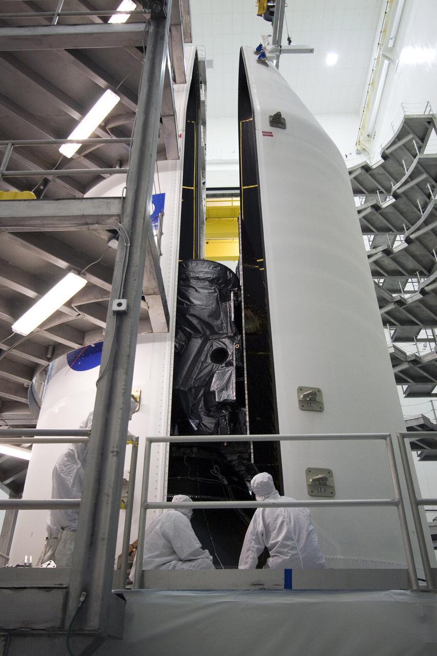 CAPE CANAVERAL, Fla. – At the Astrotech Space Operations facility in Titusville, Fla., spacecraft technicians guide the second half of the Delta IV payload fairing that will enclose NASA's GOES-P meteorological satellite around the spacecraft. The fairing is a molded clamshell covering that fits flush with the outside surface of the rocket and forms an aerodynamic nose cone, protecting the spacecraft during launch and ascent. GOES-P, the latest Geostationary Operational Environmental Satellite, was developed by NASA for the National Oceanic and Atmospheric Administration, or NOAA. GOES-P is designed to watch for storm development and observed current weather conditions on Earth. Launch of GOES-P is targeted for March 1 from Launch Complex 37 aboard a United Launch Alliance Delta IV rocket. For information on GOES-P, visit http:__www.nasa.gov_mission_pages_GOES-P_main_index.html. Photo credit: NASA_Jack Pfaller