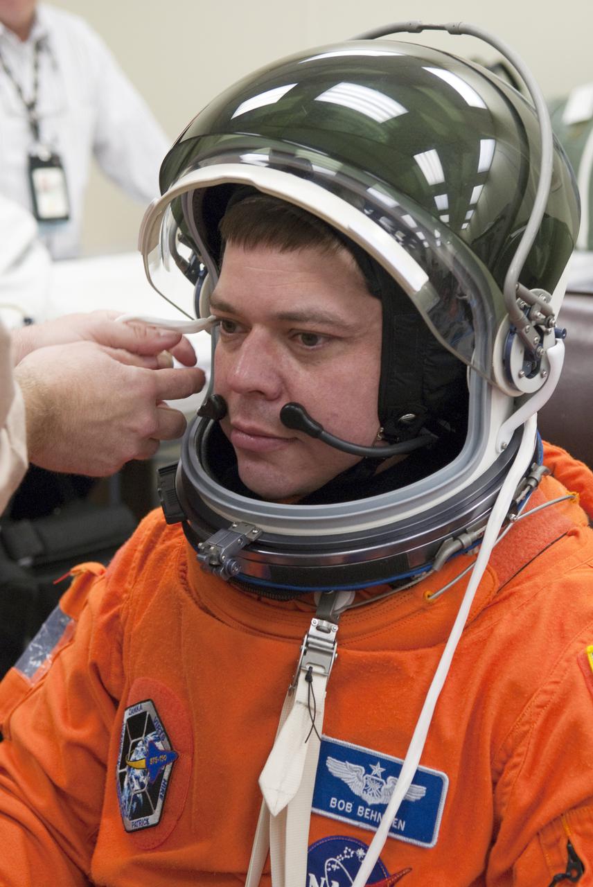 CAPE CANAVERAL, Fla. - In the Operations and Checkout Building at NASA's Kennedy Space Center in Florida, the astronauts of space shuttle Endeavour's STS-130 crew put on their launch-and-entry suits before heading to the Astrovan for the ride to Launch Pad 39A.  Mission Specialist Robert Behnken, seen here, has help checking the connections with his suit's helmet.  The primary payload for the STS-130 mission to the International Space Station is the Tranquility node, a pressurized module that will provide additional room for crew members and many of the station's life support and environmental control systems. Attached to one end of Tranquility is a cupola, a unique work area with six windows on its sides and one on top.  The cupola resembles a circular bay window and will provide a vastly improved view of the station's exterior. The multi-directional view will allow the crew to monitor spacewalks and docking operations, as well as provide a spectacular view of Earth and other celestial objects. The module was built in Turin, Italy, by Thales Alenia Space for the European Space Agency.  Endeavour's launch is set for Feb. 7 at 4:39 a.m. EST.  For information on the STS-130 mission and crew, visit http:__www.nasa.gov_mission_pages_shuttle_shuttlemissions_sts130_index.html.  Photo credit: NASA_Kim Shiflett