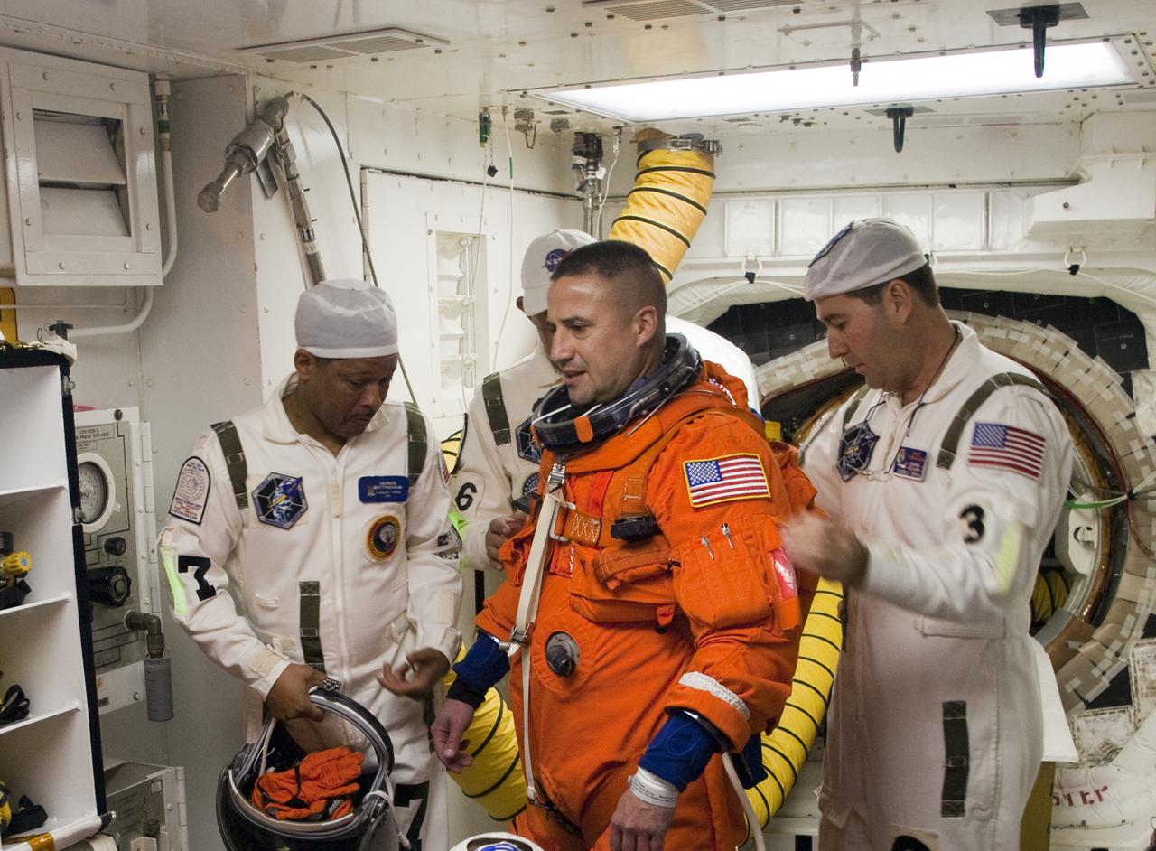 CAPE CANAVERAL, Fla. - At Launch Pad 39A at NASA's Kennedy Space Center in Florida, United Space Alliance suit technicians ensure the proper fit of the launch-and-entry suits of the astronauts on the STS-130 crew.  Commander George Zamka, seen here in the White Room, prepares to enter space shuttle Endeavour.  The primary payload for the STS-130 mission to the International Space Station is the Tranquility node, a pressurized module that will provide additional room for crew members and many of the station's life support and environmental control systems. Attached to one end of Tranquility is a cupola, a unique work area with six windows on its sides and one on top.  The cupola resembles a circular bay window and will provide a vastly improved view of the station's exterior. The multi-directional view will allow the crew to monitor spacewalks and docking operations, as well as provide a spectacular view of Earth and other celestial objects. The module was built in Turin, Italy, by Thales Alenia Space for the European Space Agency.  Endeavour's launch is set for Feb. 7 at 4:39 a.m. EST.  For information on the STS-130 mission and crew, visit http:__www.nasa.gov_mission_pages_shuttle_shuttlemissions_sts130_index.html.  Photo credit: NASA_Sandra Joseph and Kevin O'Connell