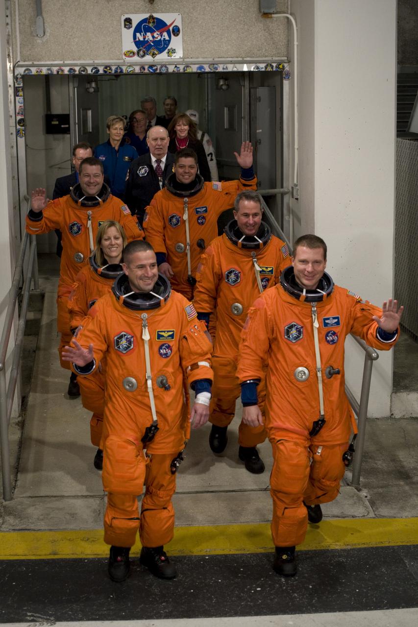 CAPE CANAVERAL, Fla. - At NASA's Kennedy Space Center in Florida, the astronauts on space shuttle Endeavour's STS-130 crew, dressed in their orange launch-and-entry suits, wave to spectators as they walk out of the Operations and Checkout Building for the ride in the Astrovan to Launch Pad 39A. In the left column, from the front, are Commander George Zamka and Mission Specialists Kathryn Hire and Nicholas Patrick.  In the right column, from the front, are Pilot Terry Virts and Mission Specialists Stephen Robinson and Robert Behnken.  This is the second launch attempt for space shuttle Endeavour's STS-130 crew.  The first attempt on Feb. 7 was scrubbed due to unfavorable weather. The primary payload for the STS-130 mission to the International Space Station is the Tranquility node, a pressurized module that will provide additional room for crew members and many of the station's life support and environmental control systems. Attached to one end of Tranquility is a cupola, a unique work area with six windows on its sides and one on top.  The cupola resembles a circular bay window and will provide a vastly improved view of the station's exterior. The multi-directional view will allow the crew to monitor spacewalks and docking operations, as well as provide a spectacular view of Earth and other celestial objects. The module was built in Turin, Italy, by Thales Alenia Space for the European Space Agency.  Endeavour's launch is set for Feb. 8 at 4:14 a.m. EST.  For information on the STS-130 mission and crew, visit http:__www.nasa.gov_mission_pages_shuttle_shuttlemissions_sts130_index.html.  Photo courtesy of Scott Andrews