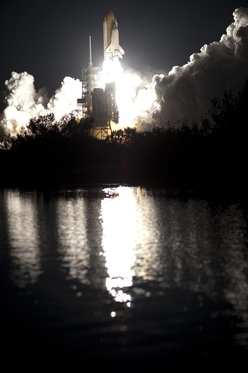 CAPE CANAVERAL, Fla. - Still water near Launch Pad 39A catches the reflection of space shuttle Endeavour as it leaps into the night sky over NASA's Kennedy Space Center in Florida. Launch of the STS-130 mission to the International Space Station was at 4:14 a.m. EST. This was the second launch attempt for space shuttle Endeavour's STS-130 crew and the final scheduled space shuttle night launch. The first attempt on Feb. 7 was scrubbed due to unfavorable weather. The primary payload for the STS-130 mission to the International Space Station is the Tranquility node, a pressurized module that will provide additional room for crew members and many of the station's life support and environmental control systems. Attached to one end of Tranquility is a cupola, a unique work area with six windows on its sides and one on top. The cupola resembles a circular bay window and will provide a vastly improved view of the station's exterior. The multi-directional view will allow the crew to monitor spacewalks and docking operations, as well as provide a spectacular view of Earth and other celestial objects. The module was built in Turin, Italy, by Thales Alenia Space for the European Space Agency. For information on the STS-130 mission and crew, visit http:__www.nasa.gov_mission_pages_shuttle_shuttlemissions_sts130_index.html. Photo credit: NASA_Tony Gray and Tom Farrar Sr.