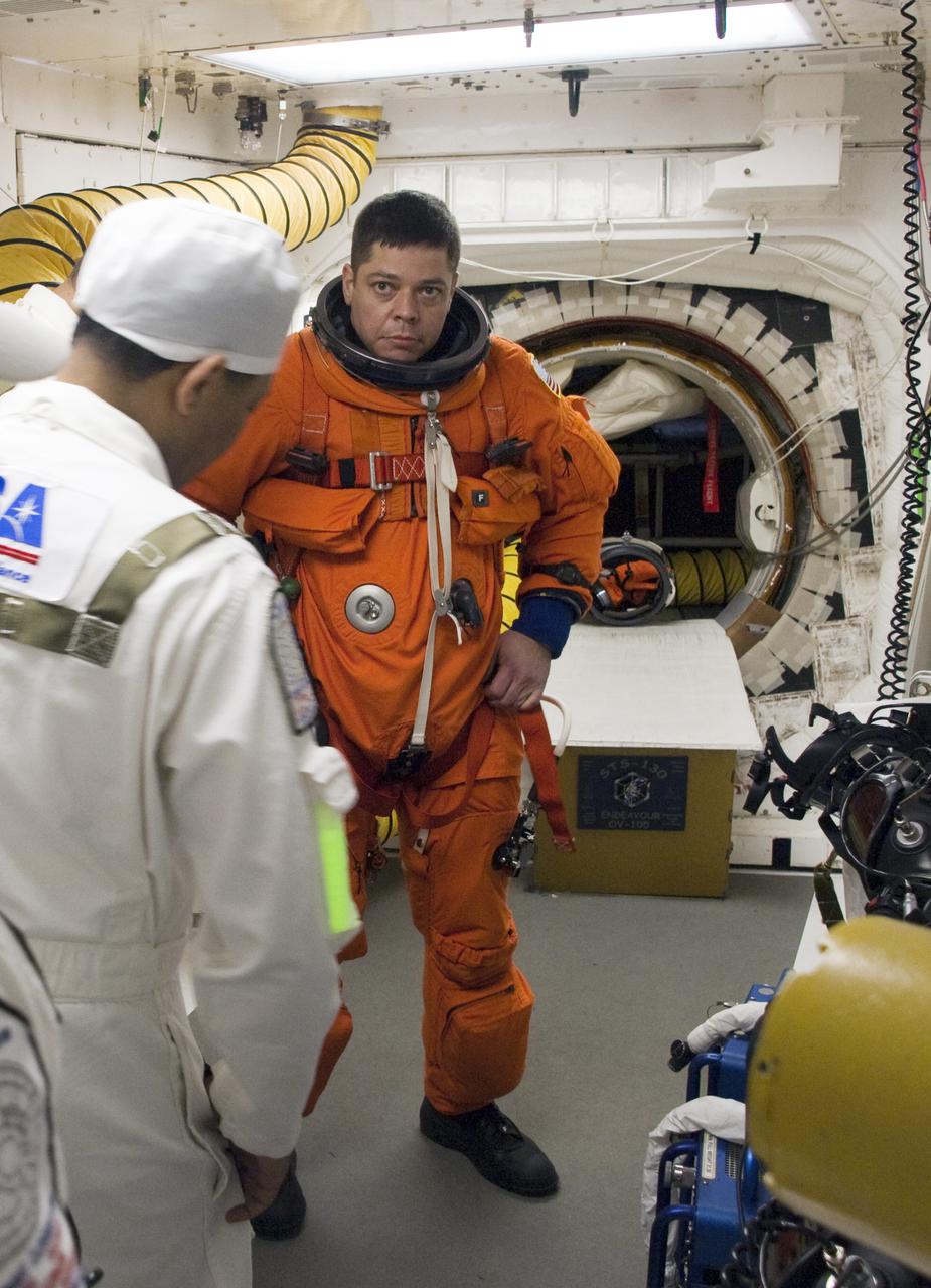 CAPE CANAVERAL, Fla. - In the White Room at Launch Pad 39A on NASA's Kennedy Space Center in Florida, a United Space Alliance suit technician ensures the proper fit of the launch-and-entry suit of STS-130 Mission Specialist Robert Behnken as he prepares to enter space shuttle Endeavour for launch. This is the second launch attempt for space shuttle Endeavour's STS-130 crew. The first attempt on Feb. 7 was scrubbed due to unfavorable weather. The primary payload for the STS-130 mission to the International Space Station is the Tranquility node, a pressurized module that will provide additional room for crew members and many of the station's life support and environmental control systems. Attached to one end of Tranquility is a cupola, a unique work area with six windows on its sides and one on top. The cupola resembles a circular bay window and will provide a vastly improved view of the station's exterior. The multi-directional view will allow the crew to monitor spacewalks and docking operations, as well as provide a spectacular view of Earth and other celestial objects. The module was built in Turin, Italy, by Thales Alenia Space for the European Space Agency. Endeavour's launch is set for Feb. 8 at 4:14 a.m. EST. For information on the STS-130 mission and crew, visit http:__www.nasa.gov_mission_pages_shuttle_shuttlemissions_sts130_index.html. Photo credit: NASA_Sandra Joseph and Kevin O'Connell