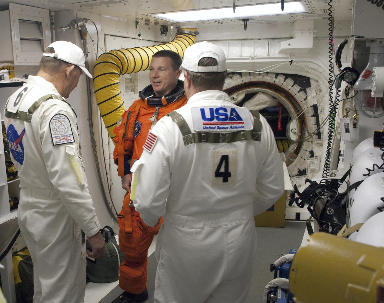 CAPE CANAVERAL, Fla. - In the White Room at Launch Pad 39A on NASA's Kennedy Space Center in Florida, United Space Alliance suit technicians and NASA quality inspectors ensure the proper fit of the launch-and-entry suit of STS-130 Pilot Terry Virts as he prepares to enter space shuttle Endeavour for launch.  This is the second launch attempt for space shuttle Endeavour's STS-130 crew.  The first attempt on Feb. 7 was scrubbed due to unfavorable weather. The primary payload for the STS-130 mission to the International Space Station is the Tranquility node, a pressurized module that will provide additional room for crew members and many of the station's life support and environmental control systems. Attached to one end of Tranquility is a cupola, a unique work area with six windows on its sides and one on top.  The cupola resembles a circular bay window and will provide a vastly improved view of the station's exterior. The multi-directional view will allow the crew to monitor spacewalks and docking operations, as well as provide a spectacular view of Earth and other celestial objects. The module was built in Turin, Italy, by Thales Alenia Space for the European Space Agency.  Endeavour's launch is set for Feb. 8 at 4:14 a.m. EST.  For information on the STS-130 mission and crew, visit http:__www.nasa.gov_mission_pages_shuttle_shuttlemissions_sts130_index.html.  Photo credit: NASA_Sandra Joseph and Kevin O'Connell