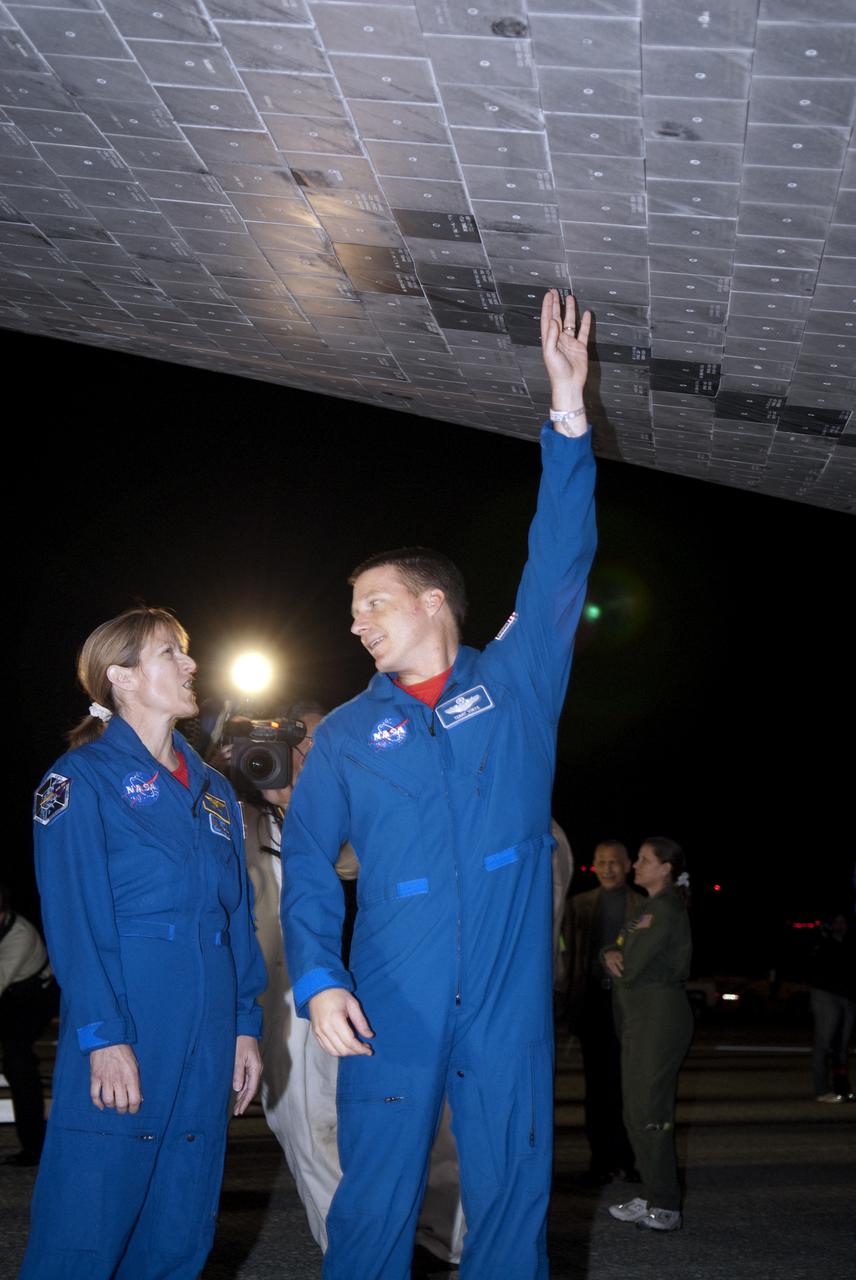 CAPE CANAVERAL, Fla. - STS-130 Mission Specialist Kathryn Hire, left, and Pilot Terry Virts inspect the thermal protection system tiles under space shuttle Endeavour following its successful landing on Runway 15 at the Shuttle Landing Facility at NASA's Kennedy Space Center in Florida. After 14 days in space, Endeavour's 5.7-million-mile STS-130 mission was completed on orbit 217.  Main gear touchdown was at 10:20:31 p.m. EST followed by nose gear touchdown at 10:20:39 p.m. and wheels stop at 10:22:10 p.m.  It was the 23rd night landing in shuttle history and the 17th at Kennedy.  During Endeavour's STS-130 mission, astronauts installed the Tranquility node, a module that provides additional room for crew members and many of the station's life support and environmental control systems. Attached to Tranquility is a cupola with seven windows that provide a panoramic view of Earth, celestial objects and visiting spacecraft. The module was built in Turin, Italy, by Thales Alenia Space for the European Space Agency.  The orbiting laboratory is approximately 90 percent complete now in terms of mass.  STS-130 was the 24th flight for Endeavour, the 32nd shuttle mission devoted to ISS assembly and maintenance, and the 130th shuttle mission to date.  For information on the STS-130 mission and crew, visit http:__www.nasa.gov_mission_pages_shuttle_shuttlemissions_sts130_index.html.  Photo credit: NASA_Kim Shiflett