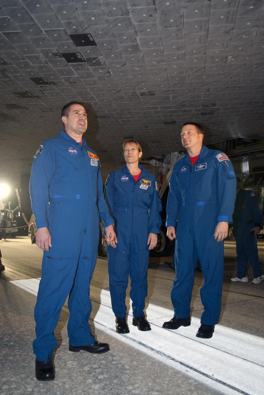 CAPE CANAVERAL, Fla. - From left, STS-130 Commander George Zamka, Mission Specialist Kathryn Hire and Pilot Terry Virts inspect the thermal protection system tiles under space shuttle Endeavour following its successful landing on Runway 15 at the Shuttle Landing Facility at NASA's Kennedy Space Center in Florida. After 14 days in space, Endeavour's 5.7-million-mile STS-130 mission was completed on orbit 217.  Main gear touchdown was at 10:20:31 p.m. EST followed by nose gear touchdown at 10:20:39 p.m. and wheels stop at 10:22:10 p.m.  It was the 23rd night landing in shuttle history and the 17th at Kennedy.  During Endeavour's STS-130 mission, astronauts installed the Tranquility node, a module that provides additional room for crew members and many of the station's life support and environmental control systems. Attached to Tranquility is a cupola with seven windows that provide a panoramic view of Earth, celestial objects and visiting spacecraft. The module was built in Turin, Italy, by Thales Alenia Space for the European Space Agency.  The orbiting laboratory is approximately 90 percent complete now in terms of mass.  STS-130 was the 24th flight for Endeavour, the 32nd shuttle mission devoted to ISS assembly and maintenance, and the 130th shuttle mission to date.  For information on the STS-130 mission and crew, visit http:__www.nasa.gov_mission_pages_shuttle_shuttlemissions_sts130_index.html.  Photo credit: NASA_Kim Shiflett