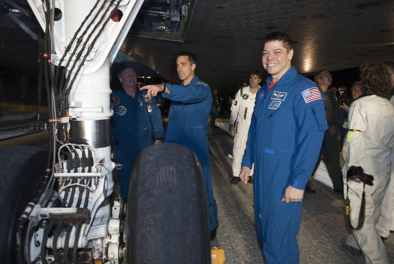 CAPE CANAVERAL, Fla. - STS-130 Mission Specialist Robert Behnken, right, inspects the landing gear on space shuttle Endeavour following its successful landing on Runway 15 at the Shuttle Landing Facility at NASA's Kennedy Space Center in Florida. After 14 days in space, Endeavour's 5.7-million-mile STS-130 mission was completed on orbit 217. Main gear touchdown was at 10:20:31 p.m. EST followed by nose gear touchdown at 10:20:39 p.m. and wheels stop at 10:22:10 p.m. It was the 23rd night landing in shuttle history and the 17th at Kennedy. During Endeavour's STS-130 mission, astronauts installed the Tranquility node, a module that provides additional room for crew members and many of the station's life support and environmental control systems. Attached to Tranquility is a cupola with seven windows that provide a panoramic view of Earth, celestial objects and visiting spacecraft. The module was built in Turin, Italy, by Thales Alenia Space for the European Space Agency. The orbiting laboratory is approximately 90 percent complete now in terms of mass. STS-130 was the 24th flight for Endeavour, the 32nd shuttle mission devoted to ISS assembly and maintenance, and the 130th shuttle mission to date. For information on the STS-130 mission and crew, visit http:__www.nasa.gov_mission_pages_shuttle_shuttlemissions_sts130_index.html. Photo credit: NASA_Kim Shiflett