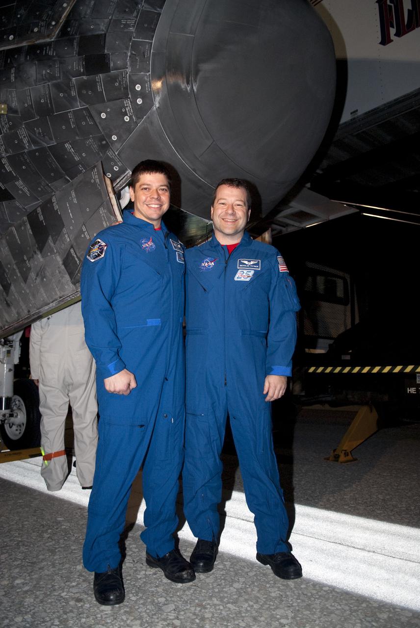 CAPE CANAVERAL, Fla. - STS-130 Mission Specialists Robert Behnken, left, and Nicholas Patrick pause for a photograph under space shuttle Endeavour's nosecone following its successful landing on Runway 15 at the Shuttle Landing Facility at NASA's Kennedy Space Center in Florida. After 14 days in space, Endeavour's 5.7-million-mile STS-130 mission was completed on orbit 217.  Main gear touchdown was at 10:20:31 p.m. EST followed by nose gear touchdown at 10:20:39 p.m. and wheels stop at 10:22:10 p.m.  It was the 23rd night landing in shuttle history and the 17th at Kennedy.  During Endeavour's STS-130 mission, astronauts installed the Tranquility node, a module that provides additional room for crew members and many of the station's life support and environmental control systems. Attached to Tranquility is a cupola with seven windows that provide a panoramic view of Earth, celestial objects and visiting spacecraft. The module was built in Turin, Italy, by Thales Alenia Space for the European Space Agency.  The orbiting laboratory is approximately 90 percent complete now in terms of mass.  STS-130 was the 24th flight for Endeavour, the 32nd shuttle mission devoted to ISS assembly and maintenance, and the 130th shuttle mission to date.  For information on the STS-130 mission and crew, visit http:__www.nasa.gov_mission_pages_shuttle_shuttlemissions_sts130_index.html.  Photo credit: NASA_Kim Shiflett