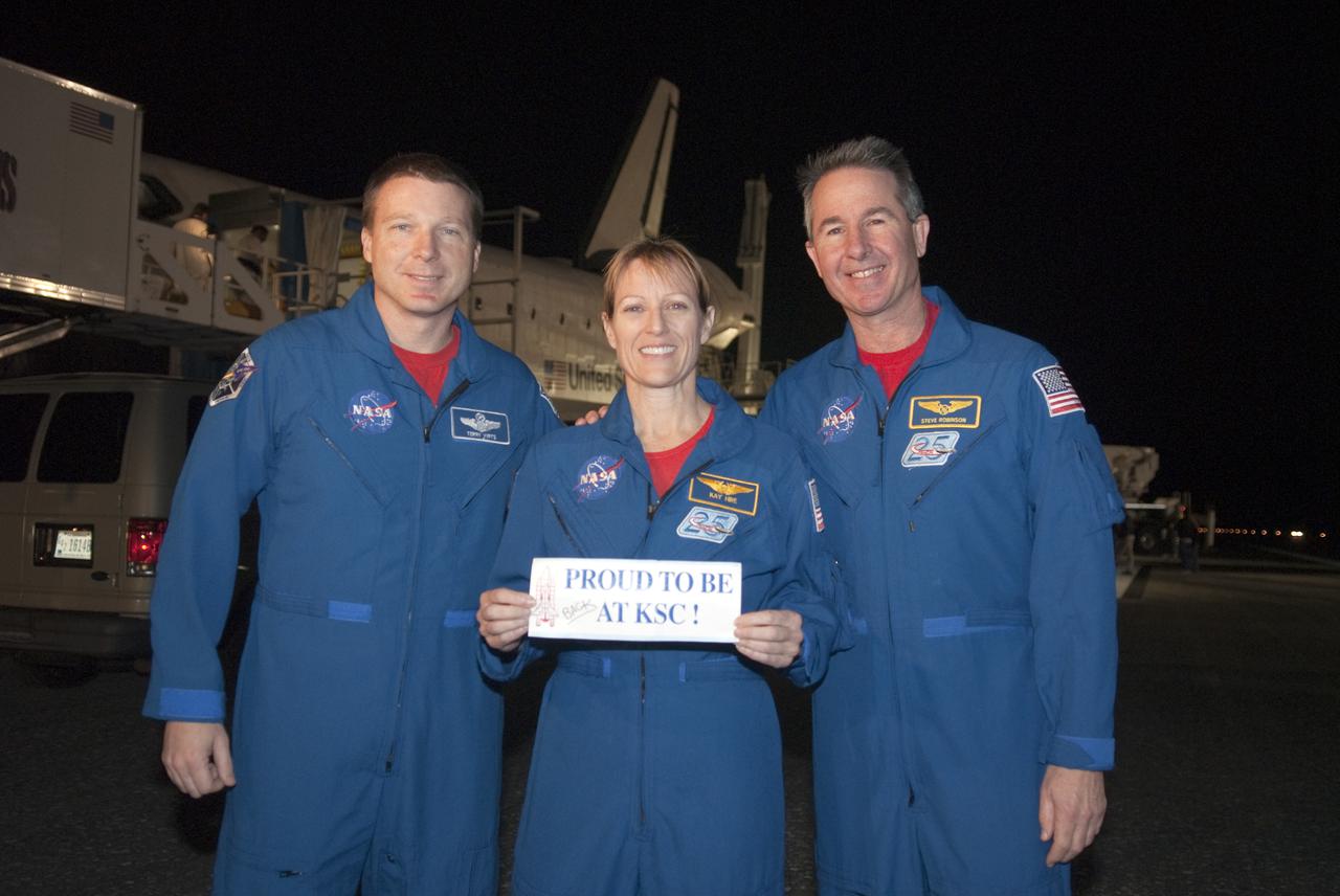 CAPE CANAVERAL, Fla. - STS-130 Mission Specialist Kathryn Hire holds up a sign proclaiming 'Proud to be at KSC_' following space shuttle Endeavour's successful landing on Runway 15 at the Shuttle Landing Facility at NASA's Kennedy Space Center in Florida. From left are Pilot Terry Virts, Hire, and Mission Specialist Stephen Robinson.  After 14 days in space, Endeavour's 5.7-million-mile STS-130 mission was completed on orbit 217.   Main gear touchdown was at 10:20:31 p.m. EST followed by nose gear touchdown at 10:20:39 p.m. and wheels stop at 10:22:10 p.m.  It was the 23rd night landing in shuttle history and the 17th at Kennedy.  During Endeavour's STS-130 mission, astronauts installed the Tranquility node, a module that provides additional room for crew members and many of the station's life support and environmental control systems. Attached to Tranquility is a cupola with seven windows that provide a panoramic view of Earth, celestial objects and visiting spacecraft. The module was built in Turin, Italy, by Thales Alenia Space for the European Space Agency.  The orbiting laboratory is approximately 90 percent complete now in terms of mass.  STS-130 was the 24th flight for Endeavour, the 32nd shuttle mission devoted to ISS assembly and maintenance, and the 130th shuttle mission to date.  For information on the STS-130 mission and crew, visit http:__www.nasa.gov_mission_pages_shuttle_shuttlemissions_sts130_index.html.  Photo credit: NASA_Kim Shiflett
