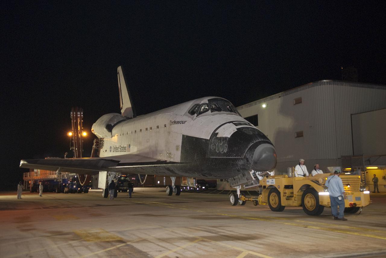 CAPE CANAVERAL, Fla. - At NASA's Kennedy Space Center in Florida, space shuttle Endeavour is towed toward the door of Orbiter Processing Facility-2.  Endeavour's touchdown at Kennedy's Shuttle Landing Facility following the STS-130 mission to the International Space Station was at 10:20 p.m. EST Feb. 21.  Processing now will begin for Endeavour's next flight, STS-134.  The six-member STS-134 crew will deliver Express Logistics Carrier 3 and the Alpha Magnetic Spectrometer to the International Space Station, as well as a variety of spare parts including two S-band communications antennas, a high-pressure gas tank, additional spare parts for Dextre and micrometeoroid debris shields. STS-134 will be the 35th shuttle mission to the station and the 133rd flight in the shuttle program.  Launch is targeted for July 29. For information on the STS-134 mission and crew, visit http:__www.nasa.gov_mission_pages_shuttle_shuttlemissions_sts134_index.html.  Photo credit: NASA_Kim Shiflett