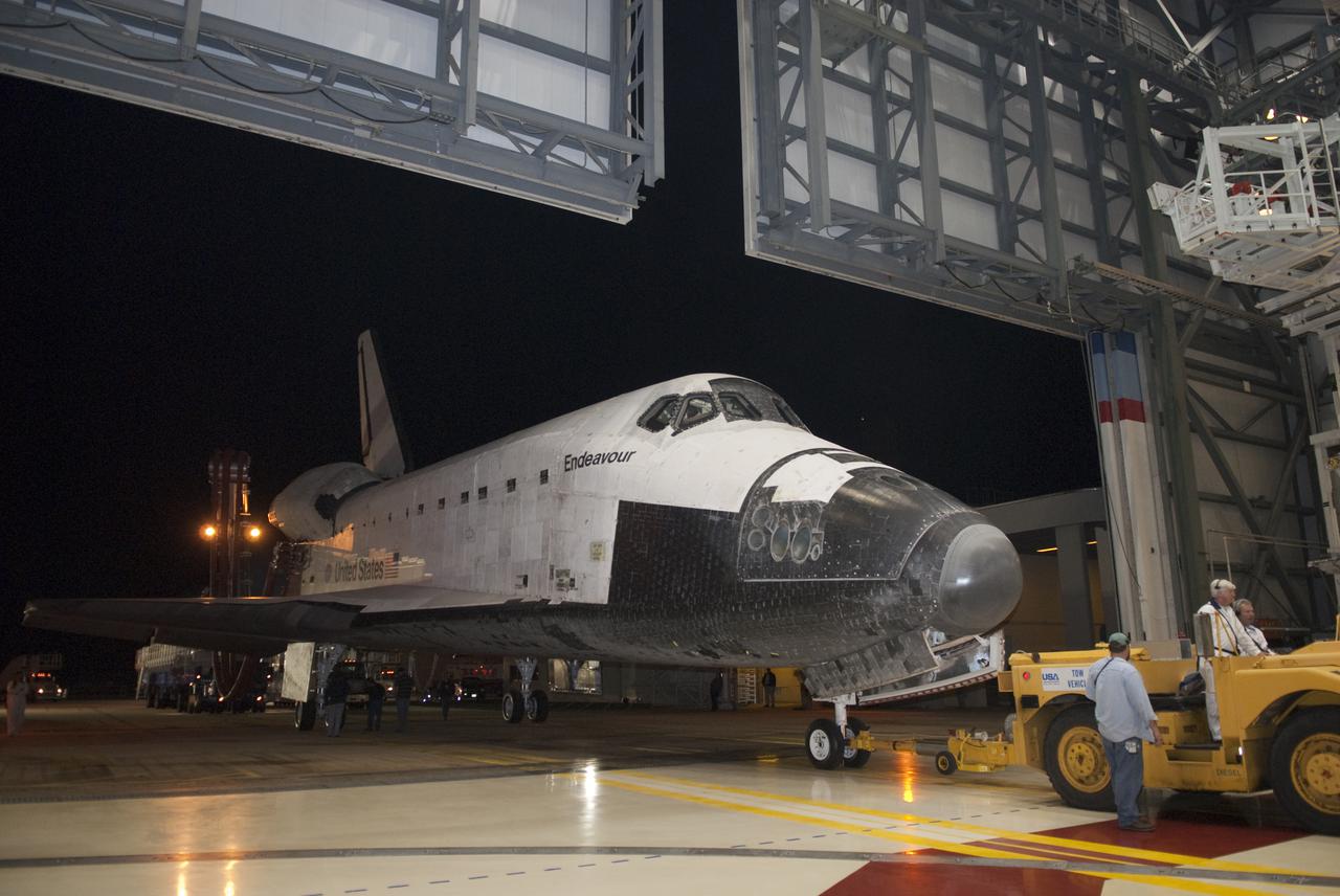 CAPE CANAVERAL, Fla. - At NASA's Kennedy Space Center in Florida, space shuttle Endeavour is towed through the door of Orbiter Processing Facility-2.  Endeavour's touchdown at Kennedy's Shuttle Landing Facility following the STS-130 mission to the International Space Station was at 10:20 p.m. EST Feb. 21.  Processing now will begin for Endeavour's next flight, STS-134.  The six-member STS-134 crew will deliver Express Logistics Carrier 3 and the Alpha Magnetic Spectrometer to the International Space Station, as well as a variety of spare parts including two S-band communications antennas, a high-pressure gas tank, additional spare parts for Dextre and micrometeoroid debris shields. STS-134 will be the 35th shuttle mission to the station and the 133rd flight in the shuttle program.  Launch is targeted for July 29. For information on the STS-134 mission and crew, visit http:__www.nasa.gov_mission_pages_shuttle_shuttlemissions_sts134_index.html.  Photo credit: NASA_Kim Shiflett