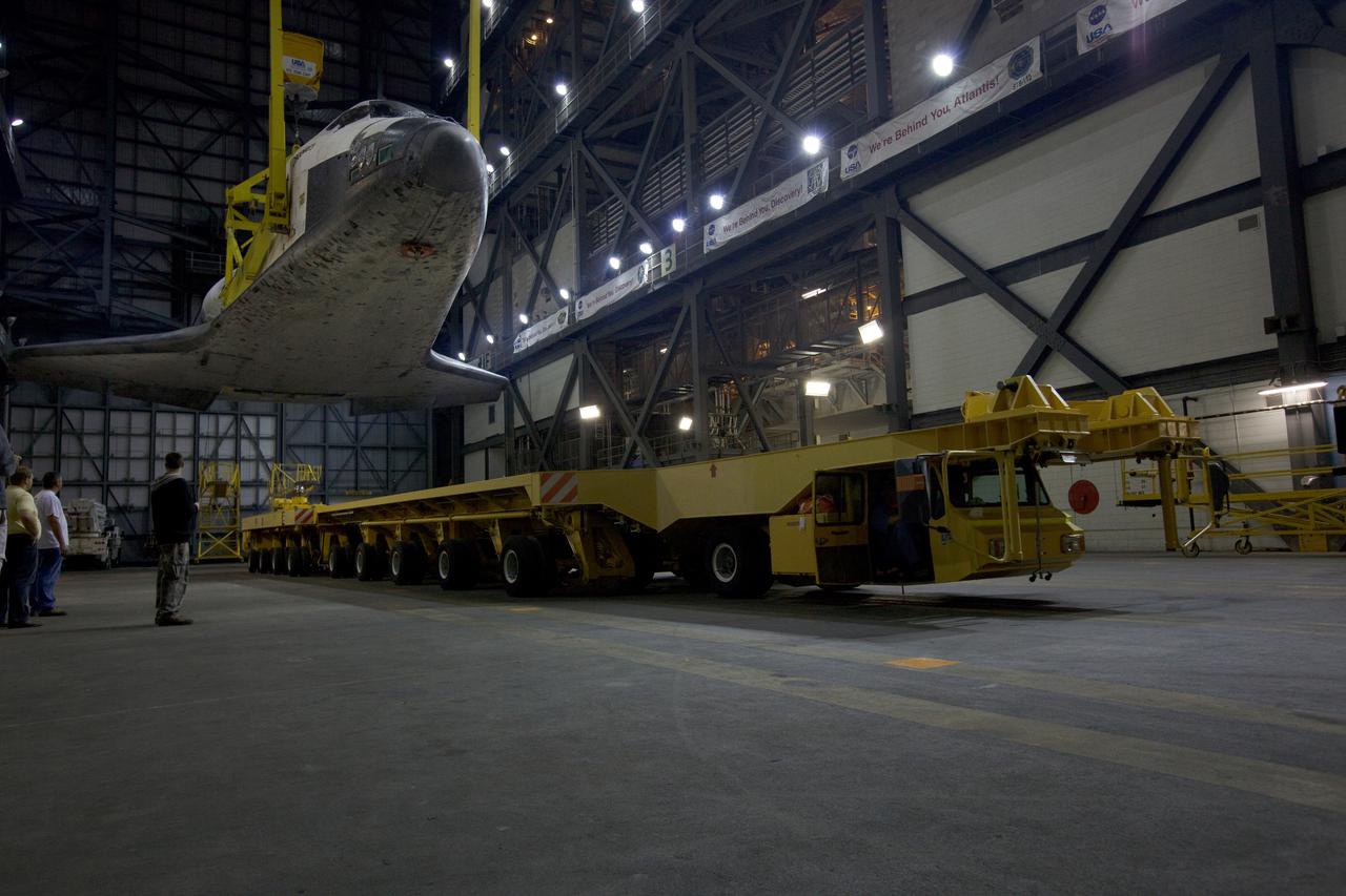 CAPE CANAVERAL, Fla. - In the transfer aisle of the Vehicle Assembly Building, or VAB, at NASA's Kennedy Space Center in Florida, space shuttle Discovery is lifted from the transporter which delivered it from the Orbiter Processing Facility.  In the high bay, Discovery will be attached to its external tank and solid rocket boosters completing the STS-131 shuttle stack. Rollout to Launch Pad 39A is planned for March 2.  The seven-member STS-131 crew will deliver the Multi-Purpose Logistics Module Leonardo, filled with resupply stowage platforms and racks, to the International Space Station aboard space shuttle Discovery.  Work to attach a spare ammonia tank assembly to the station's exterior and return a European experiment from outside the station's Columbus module will be conducted during three spacewalks.  STS-131, targeted for launch on April 5, will be the 33rd shuttle mission to the station and the 131st shuttle mission overall. For information on the STS-131 mission and crew, visit http:__www.nasa.gov_mission_pages_shuttle_shuttlemissions_sts131_index.html.  Photo courtesy of Scott Andrews and Stan Jirman