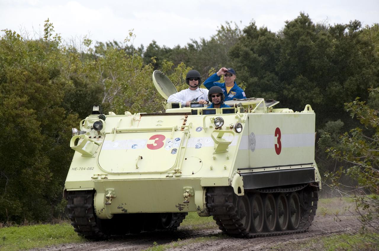 CAPE CANAVERAL, Fla. - At NASA's Kennedy Space Center in Florida, STS-131 Mission Specialist Rick Mastracchio takes his instructor, Battalion Chief David Seymour, at left, for a ride in an M-113 armored personnel carrier during driving practice.  Also along for the ride is STS-131 Commander Alan Poindexter.  An M-113 is kept at the foot of the launch pad in case an emergency egress from the vicinity of the pad is needed.  The crew members of space shuttle Discovery's STS-131 mission are at Kennedy for training related to their launch dress rehearsal, the Terminal Countdown Demonstration Test.  The seven-member crew will deliver the multi-purpose logistics module Leonardo, filled with resupply stowage platforms and racks, to the International Space Station aboard Discovery. Targeted for launch on April 5, STS-131 will be the 33rd shuttle mission to the station and the 131st shuttle mission overall. For information on the STS-131 mission and crew, visit http:__www.nasa.gov_mission_pages_shuttle_shuttlemissions_sts131_index.html. Photo credit: NASA_Kim Shiflett