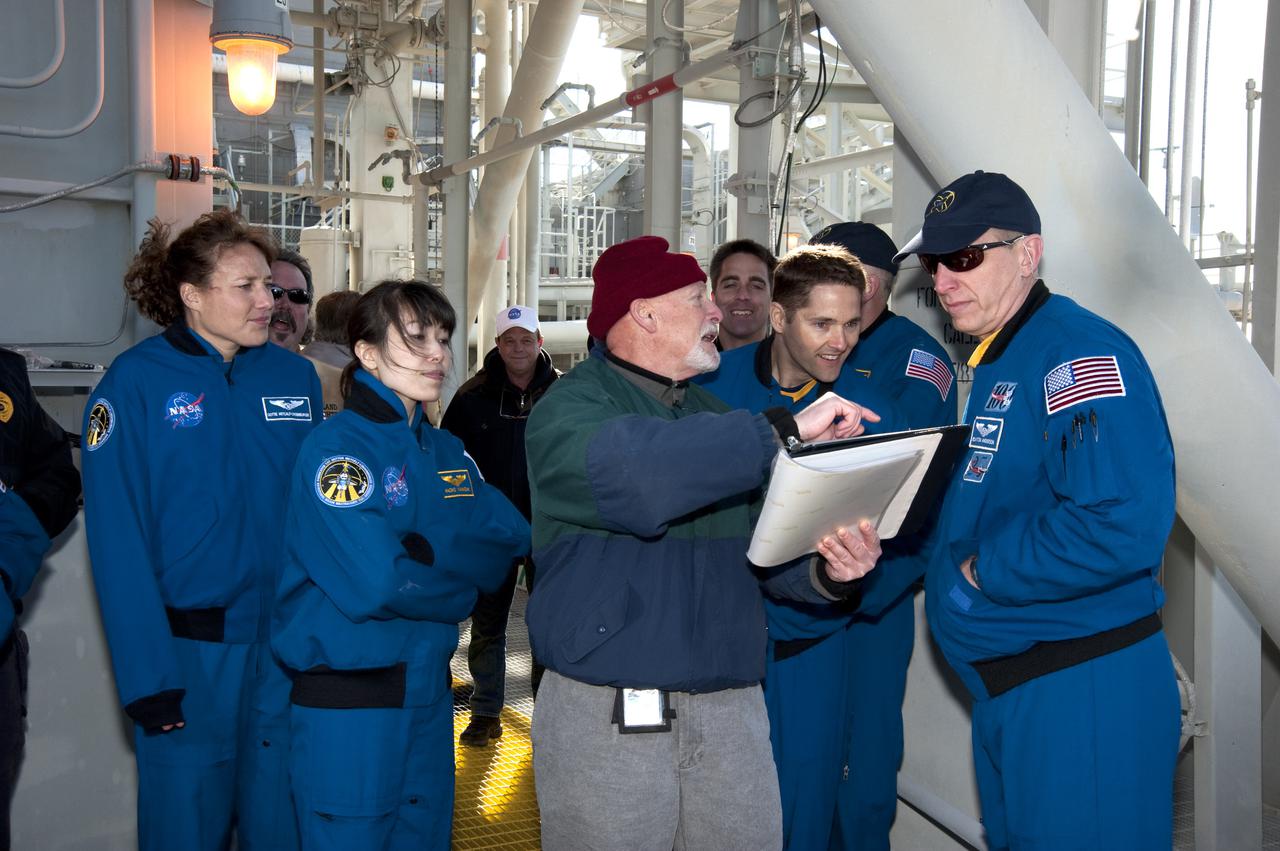 CAPE CANAVERAL, Fla. - On Launch Pad 39A at NASA's Kennedy Space Center, the members of space shuttle Discovery's STS-131 crew are instructed on emergency exit procedures on a brisk Florida morning.  From left, in the blue suits, are Mission Specialists Dorothy Metcalf-Lindenburger and Naoko Yamazaki of the Japan Aerospace Exploration Agency; Pilot James P. Dutton Jr.; and Mission Specialist Clayton Anderson.  The crew members of space shuttle Discovery's STS-131 mission are at Kennedy for training related to their launch dress rehearsal, the Terminal Countdown Demonstration Test.  The seven-member crew will deliver the multi-purpose logistics module Leonardo, filled with resupply stowage platforms and racks, to the International Space Station aboard Discovery. Targeted for launch on April 5, STS-131 will be the 33rd shuttle mission to the station and the 131st shuttle mission overall. For information on the STS-131 mission and crew, visit http:__www.nasa.gov_mission_pages_shuttle_shuttlemissions_sts131_index.html. Photo credit: NASA_Kim Shiflett