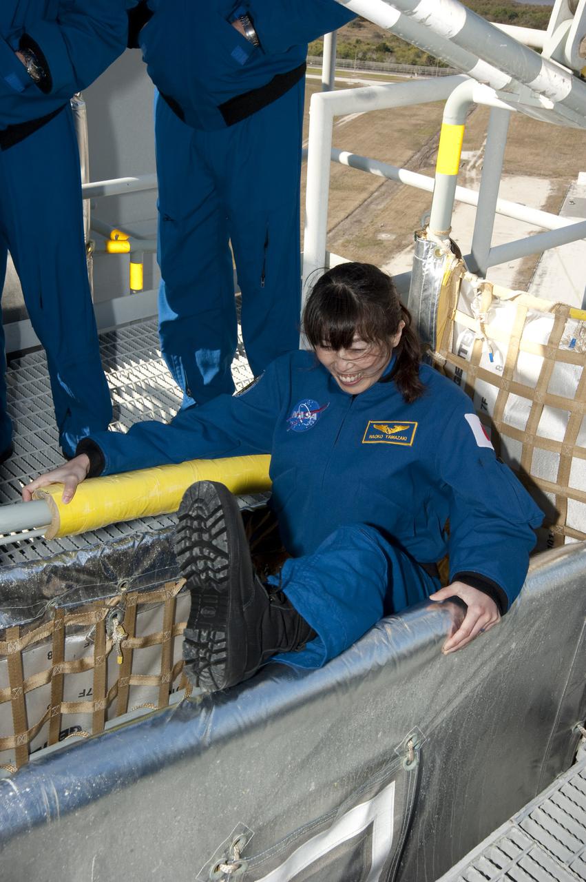 CAPE CANAVERAL, Fla. - On Launch Pad 39A at NASA's Kennedy Space Center in Florida, STS-131 Mission Specialist Naoko Yamazaki of the Japan Aerospace Exploration Agency hops into a slidewire basket during training on the emergency exit system at the pad. The system includes seven baskets suspended from seven slidewires that extend from the fixed service structure to a landing zone 1,200 feet west of the pad.  The crew members of space shuttle Discovery's STS-131 mission are at Kennedy for training related to their launch dress rehearsal, the Terminal Countdown Demonstration Test.  The seven-member crew will deliver the multi-purpose logistics module Leonardo, filled with resupply stowage platforms and racks, to the International Space Station aboard Discovery. Targeted for launch on April 5, STS-131 will be the 33rd shuttle mission to the station and the 131st shuttle mission overall. For information on the STS-131 mission and crew, visit http:__www.nasa.gov_mission_pages_shuttle_shuttlemissions_sts131_index.html. Photo credit: NASA_Kim Shiflett