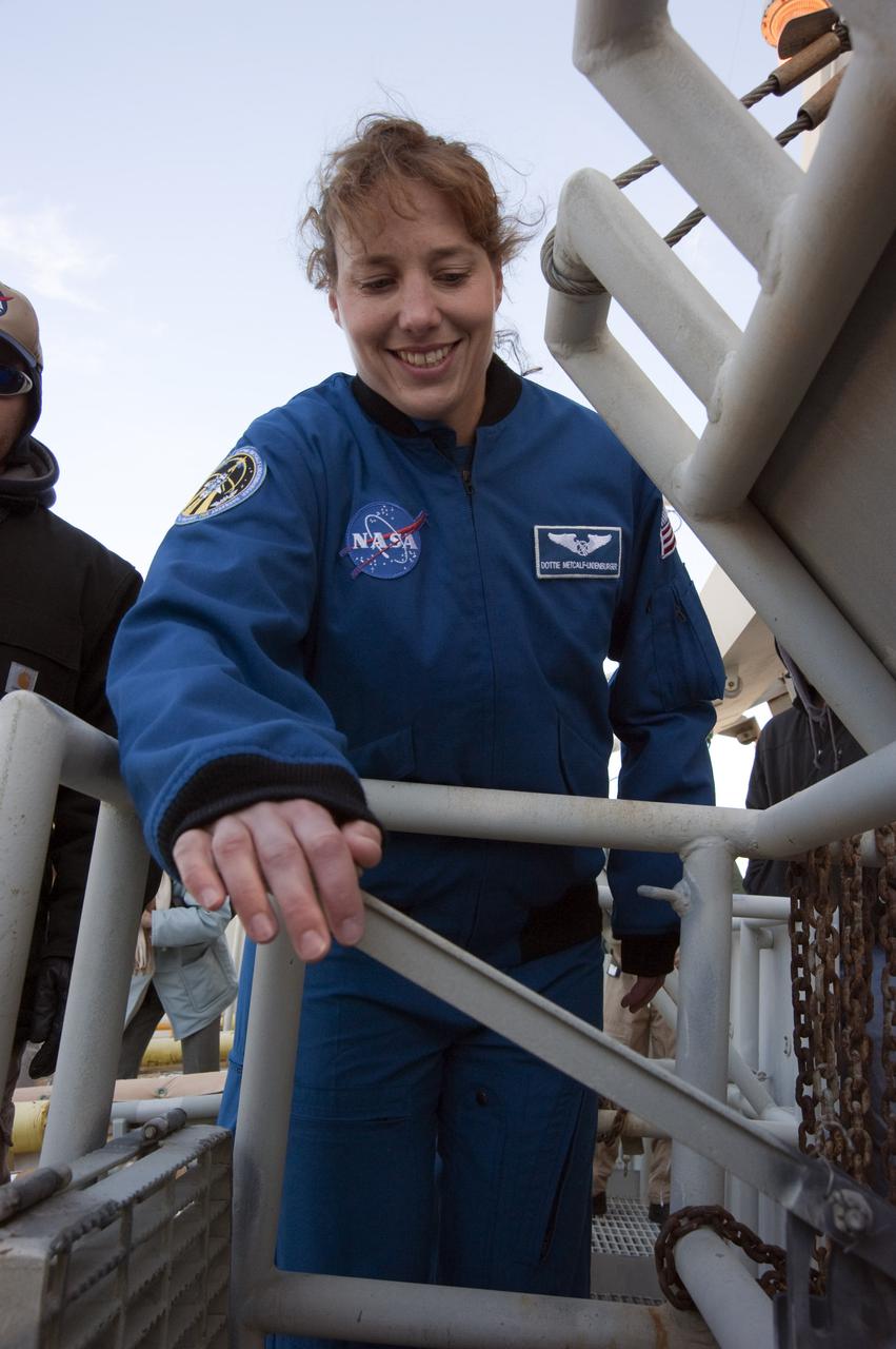 CAPE CANAVERAL, Fla. - On Launch Pad 39A at NASA's Kennedy Space Center in Florida, STS-131 Mission Specialists Dorothy Metcalf-Lindenburger familiarizes herself with the operation of a slidewire basket during training on the emergency exit system at the pad. The system includes seven baskets suspended from seven slidewires that extend from the fixed service structure to a landing zone 1,200 feet west of the pad.  The crew members of space shuttle Discovery's STS-131 mission are at Kennedy for training related to their launch dress rehearsal, the Terminal Countdown Demonstration Test.  The seven-member crew will deliver the multi-purpose logistics module Leonardo, filled with resupply stowage platforms and racks, to the International Space Station aboard Discovery. Targeted for launch on April 5, STS-131 will be the 33rd shuttle mission to the station and the 131st shuttle mission overall. For information on the STS-131 mission and crew, visit http:__www.nasa.gov_mission_pages_shuttle_shuttlemissions_sts131_index.html. Photo credit: NASA_Kim Shiflett