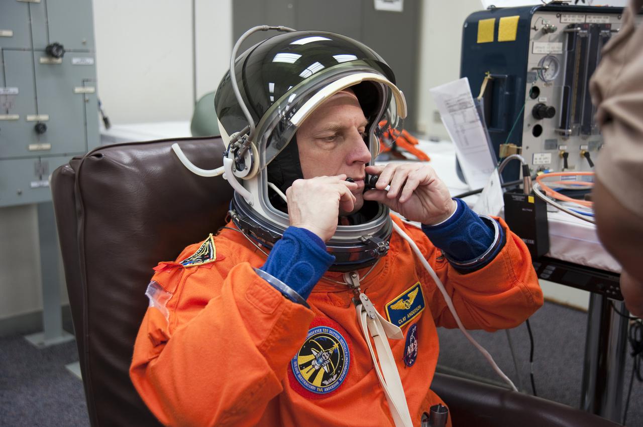 CAPE CANAVERAL, Fla. - In the Operations and Checkout Building at NASA's Kennedy Space Center in Florida, STS-131 Mission Specialist Clayton Anderson adjusts his helmet. The members of space shuttle Discovery's STS-131 crew put on their launch-and-entry suits before heading to the Astrovan for the ride to Launch Pad 39A. The crew is participating in the Terminal Countdown Demonstration Test, or TCDT, a dress rehearsal for launch. TCDT includes training on the emergency egress systems at the launch pad, driving practice of the M-113 armored personnel carrier and a simulated launch countdown. The crew will deliver the multi-purpose logistics module Leonard, filled with resupply stowage platforms and science racks, to the International Space Station. STS-131, targeted for launch on April 5, will be the 33rd shuttle mission to the station and the 131st shuttle mission overall. For information on the STS-131 mission and crew, visit http:__www.nasa.gov_mission_pages_shuttle_shuttlemissions_sts131_index.htm. Photo credit: NASA_Kim Shiflett