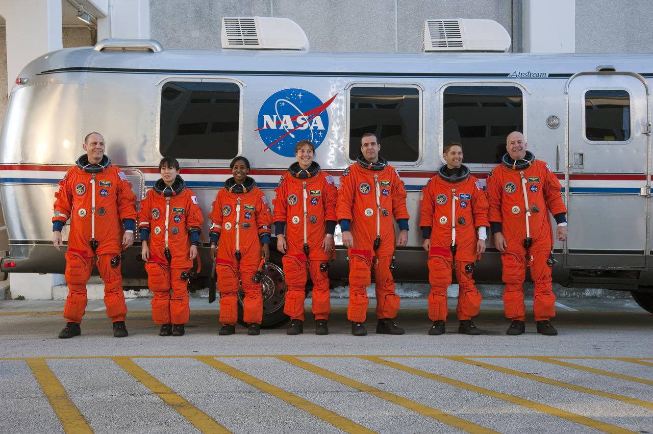 CAPE CANAVERAL, Fla. - At the Operations and Checkout Building at NASA's Kennedy Space Center in Florida, members of space shuttle Discovery's STS-131 crew pose for a group portrait in their launch-and-entry suits before boarding the Astrovan for the ride to Launch Pad 39A. The crew is participating in the Terminal Countdown Demonstration Test, or TCDT.  From left are Mission Specialists Clayton Anderson, Naoko Yamazaki of the Japan Aerospace Exploration Agency, Stephanie Wilson, Dorothy Metcalf-Lindenburger and Rick Mastracchio; Pilot James P. Dutton Jr.; and Commander Alan Poindexter.  TCDT includes training on the emergency exit systems at the launch pad, driving practice of the M-113 armored personnel carrier and a full launch countdown dress rehearsal. The crew will deliver the multi-purpose logistics module Leonard, filled with resupply stowage platforms and science racks, to the International Space Station aboard space shuttle Discovery. STS-131, targeted for launch on April 5, will be the 33rd shuttle mission to the station and the 131st shuttle mission overall. For information on the STS-131 mission and crew, visit http:__www.nasa.gov_mission_pages_shuttle_shuttlemissions_sts131_index.htm. Photo credit: NASA_Kim Shiflett