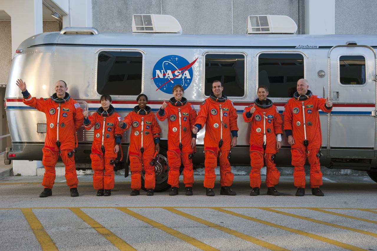 CAPE CANAVERAL, Fla. - At the Operations and Checkout Building at NASA's Kennedy Space Center in Florida, members of space shuttle Discovery's STS-131 crew, dressed in their launch-and-entry suits, signal that they are ready to board the Astrovan for the ride to Launch Pad 39A. The crew is participating in the Terminal Countdown Demonstration Test, or TCDT. From left are Mission Specialists Clayton Anderson, Naoko Yamazaki of the Japan Aerospace Exploration Agency, Stephanie Wilson, Dorothy Metcalf-Lindenburger and Rick Mastracchio; Pilot James P. Dutton Jr.; and Commander Alan Poindexter. TCDT includes training on the emergency exit systems at the launch pad, driving practice of the M-113 armored personnel carrier and a full launch countdown dress rehearsal. The crew will deliver the multi-purpose logistics module Leonard, filled with resupply stowage platforms and science racks, to the International Space Station aboard space shuttle Discovery. STS-131, targeted for launch on April 5, will be the 33rd shuttle mission to the station and the 131st shuttle mission overall. For information on the STS-131 mission and crew, visit http:__www.nasa.gov_mission_pages_shuttle_shuttlemissions_sts131_index.htm. Photo credit: NASA_Kim Shiflett