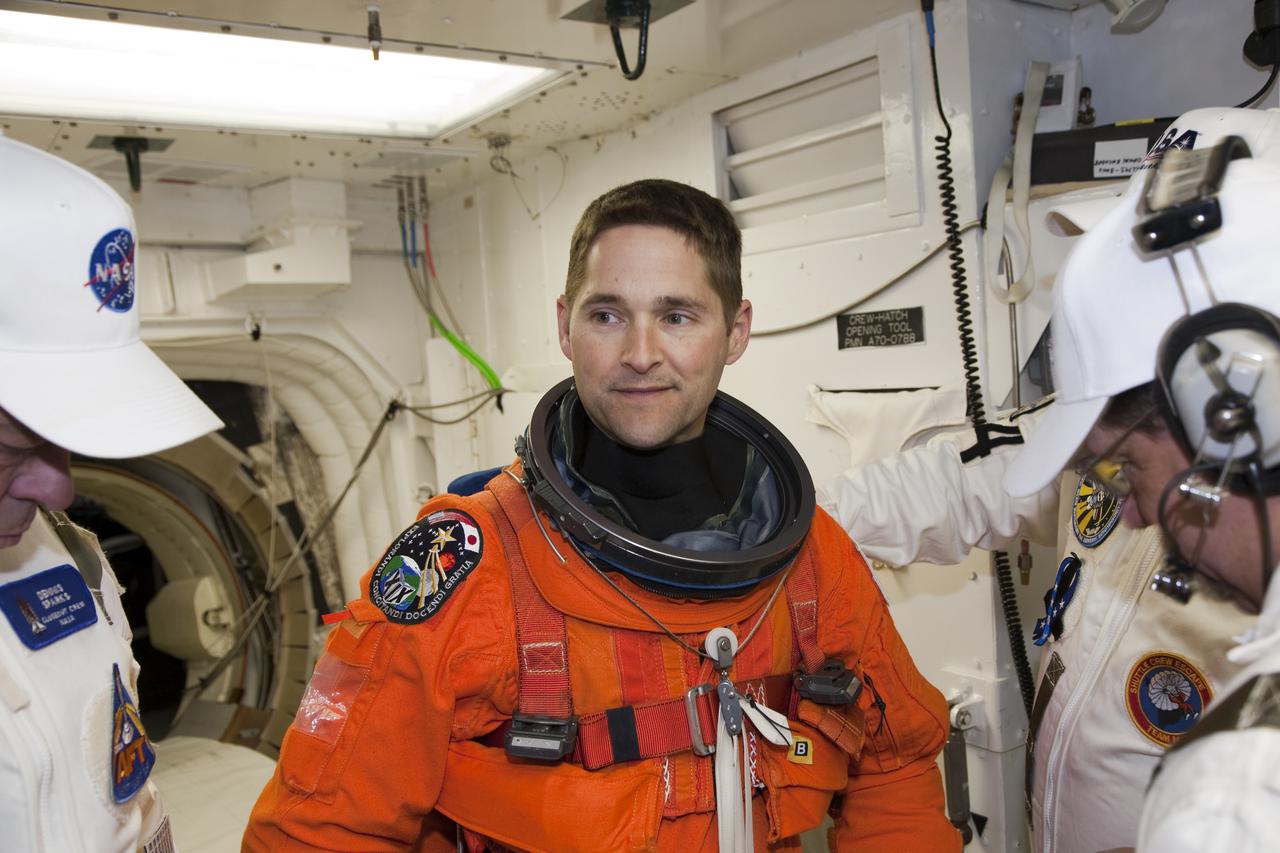 CAPE CANAVERAL, Fla. - At Launch Pad 39A at NASA's Kennedy Space Center in Florida, STS-131 Pilot James P. Dutton Jr. prepares to enter space shuttle Discovery from the pad's White Room.  The crew members of Discovery's STS-131 mission, dressed in their launch-and-entry suits, are participating in the Terminal Countdown Demonstration Test, or TCDT, a dress rehearsal for launch.  TCDT includes training on the emergency exit systems at the launch pad, driving practice of the M-113 armored personnel carrier and a simulated launch countdown. The crew will deliver the multi-purpose logistics module Leonard, filled with resupply stowage platforms and science racks, to the International Space Station. STS-131, targeted for launch on April 5, will be the 33rd shuttle mission to the station and the 131st shuttle mission overall. For information on the STS-131 mission and crew, visit http:__www.nasa.gov_mission_pages_shuttle_shuttlemissions_sts131_index.htm. Photo credit: NASA_Dimitri Gerondidakis