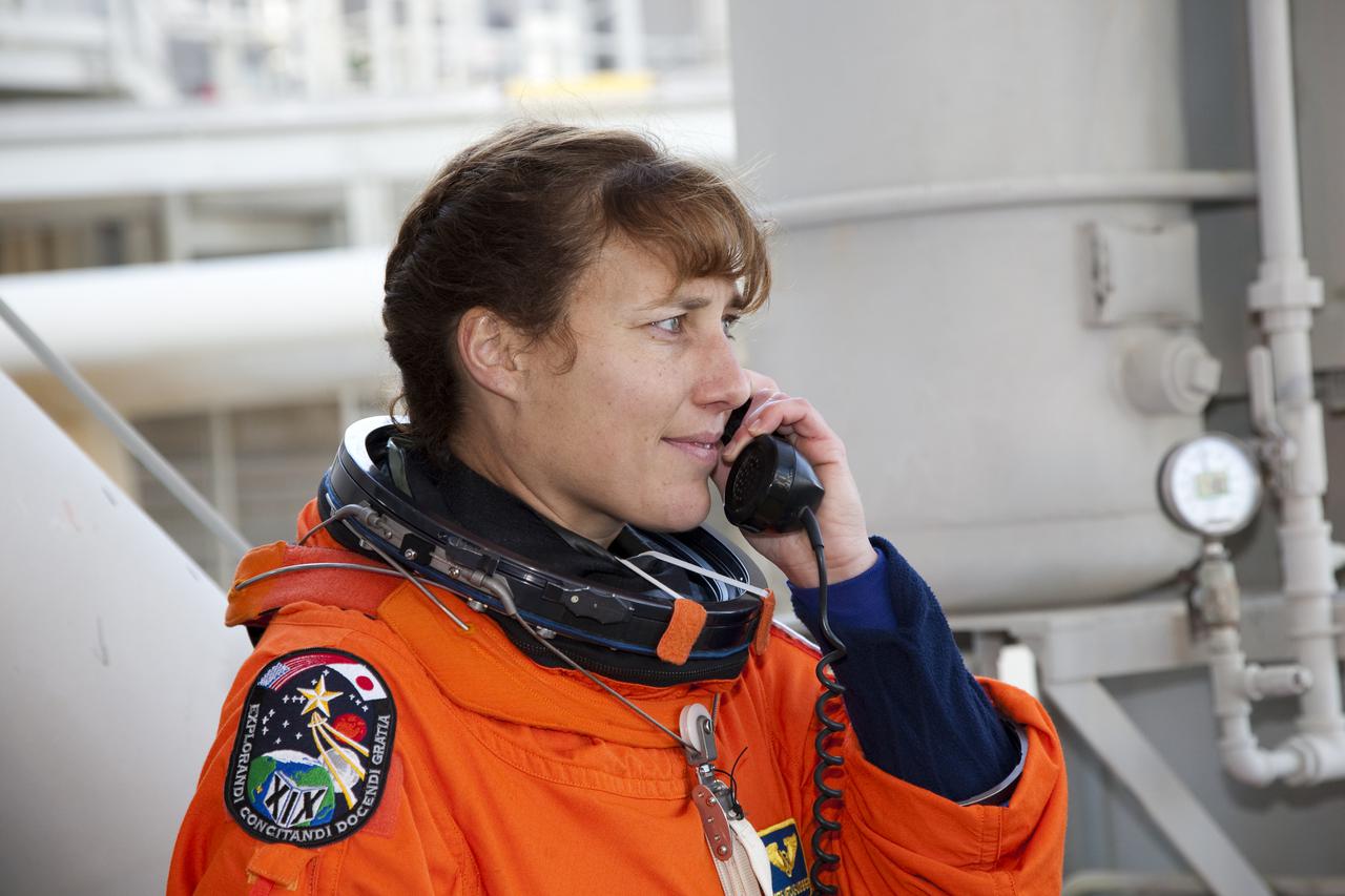 CAPE CANAVERAL, Fla. - At Launch Pad 39A at NASA's Kennedy Space Center in Florida, STS-131 Mission Specialist Dorothy Metcalf-Lindenburger awaits her turn to enter space shuttle Discovery. The crew members of Discovery's STS-131 mission, dressed in their launch-and-entry suits, are participating in the Terminal Countdown Demonstration Test, or TCDT, a dress rehearsal for launch. TCDT includes training on the emergency exit systems at the launch pad, driving practice of the M-113 armored personnel carrier and a simulated launch countdown. The crew will deliver the multi-purpose logistics module Leonard, filled with resupply stowage platforms and science racks, to the International Space Station. STS-131, targeted for launch on April 5, will be the 33rd shuttle mission to the station and the 131st shuttle mission overall. For information on the STS-131 mission and crew, visit http:__www.nasa.gov_mission_pages_shuttle_shuttlemissions_sts131_index.htm. Photo credit: NASA_Dimitri Gerondidakis