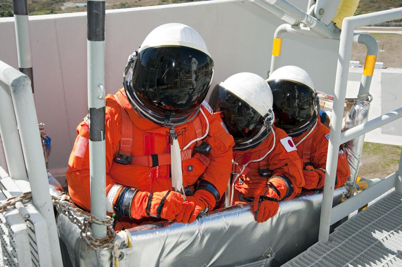 CAPE CANAVERAL, Fla. - At Launch Pad 39A at NASA's Kennedy Space Center in Florida, STS-131 crew members position themselves inside a slidewire basket as they practice emergency evacuation procedures at the pad.  Evacuation from the pad's 195-foot level is made possible by seven baskets suspended from seven slidewires that extend from the fixed service structure to a landing zone 1,200 feet west of the pad.  The crew members of space shuttle Discovery's STS-131 mission are participating in training related to their launch dress rehearsal, the Terminal Countdown Demonstration Test.  The seven-member crew will deliver the multi-purpose logistics module Leonardo, filled with resupply stowage platforms and racks, to the International Space Station aboard Discovery. Targeted for launch on April 5, STS-131 will be the 33rd shuttle mission to the station and the 131st shuttle mission overall. For information on the STS-131 mission and crew, visit http:__www.nasa.gov_mission_pages_shuttle_shuttlemissions_sts131_index.html. Photo credit: NASA_Kim Shiflett