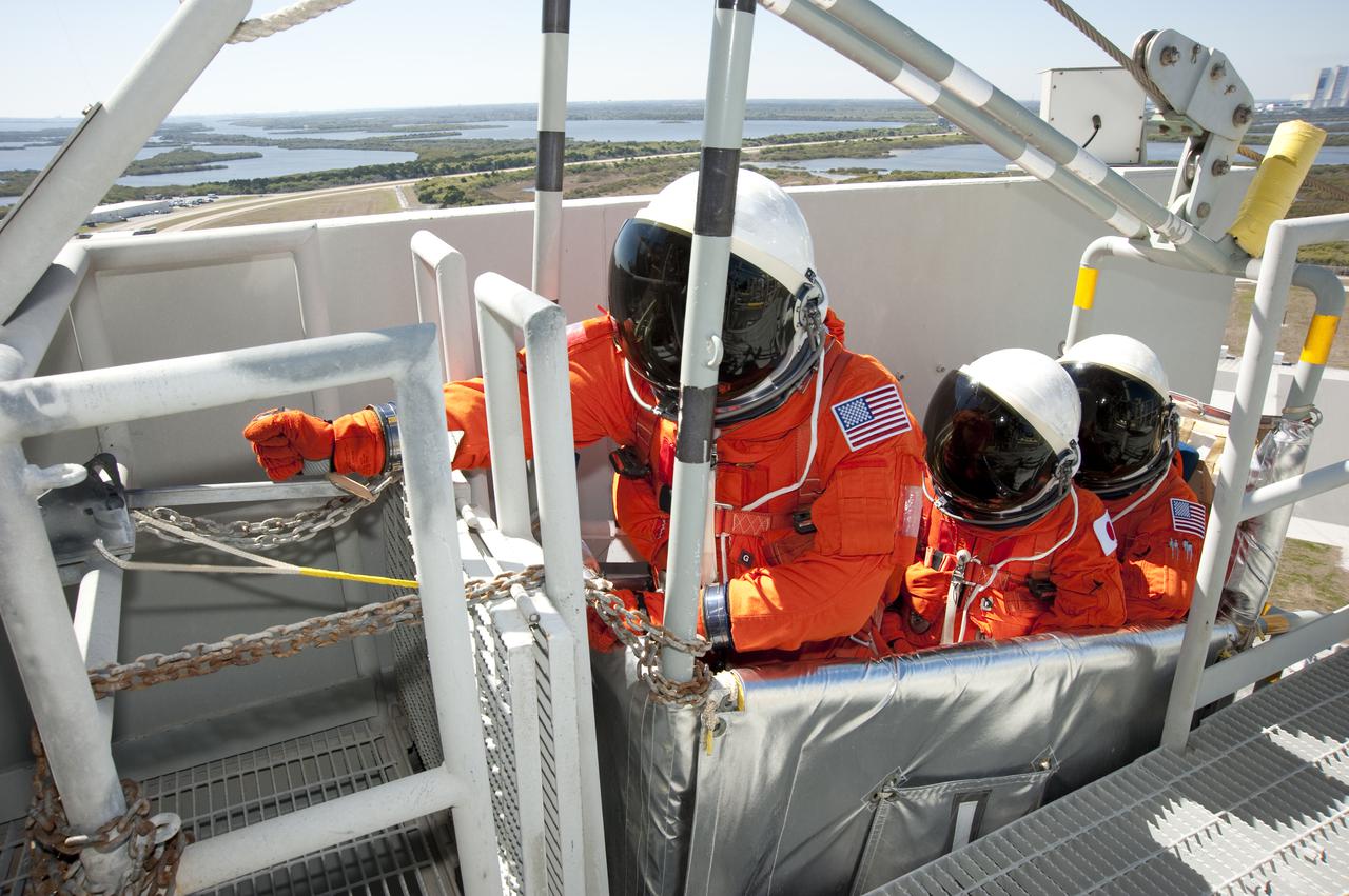 CAPE CANAVERAL, Fla. - At Launch Pad 39A at NASA's Kennedy Space Center in Florida, STS-131 crew members practice pad emergency evacuation procedures inside a slidewire basket.  Evacuation from the pad's 195-foot level is made possible by seven baskets suspended from seven slidewires that extend from the fixed service structure to a landing zone 1,200 feet west of the pad.  The crew members of space shuttle Discovery's STS-131 mission are participating in training related to their launch dress rehearsal, the Terminal Countdown Demonstration Test.  The seven-member crew will deliver the multi-purpose logistics module Leonardo, filled with resupply stowage platforms and racks, to the International Space Station aboard Discovery. Targeted for launch on April 5, STS-131 will be the 33rd shuttle mission to the station and the 131st shuttle mission overall. For information on the STS-131 mission and crew, visit http:__www.nasa.gov_mission_pages_shuttle_shuttlemissions_sts131_index.html. Photo credit: NASA_Kim Shiflett