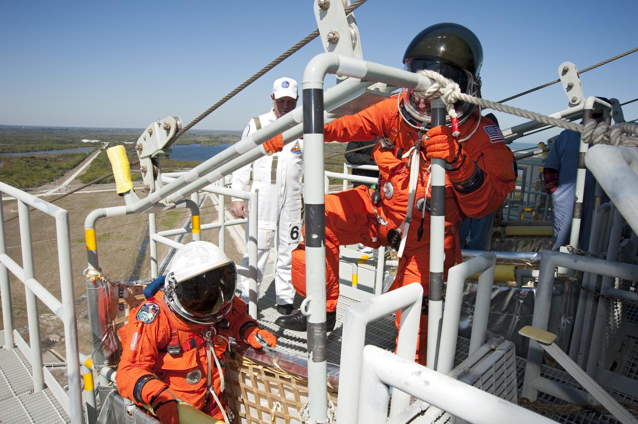 CAPE CANAVERAL, Fla. - At Launch Pad 39A at NASA's Kennedy Space Center in Florida, STS-131 Commander Alan Poindexter hops into a slidewire basket during practice for an emergency evacuation of the pad.  Evacuation from the pad's 195-foot level is made possible by seven baskets suspended from seven slidewires that extend from the fixed service structure to a landing zone 1,200 feet west of the pad.  The crew members of space shuttle Discovery's STS-131 mission are participating in training related to their launch dress rehearsal, the Terminal Countdown Demonstration Test.  The seven-member crew will deliver the multi-purpose logistics module Leonardo, filled with resupply stowage platforms and racks, to the International Space Station aboard Discovery. Targeted for launch on April 5, STS-131 will be the 33rd shuttle mission to the station and the 131st shuttle mission overall. For information on the STS-131 mission and crew, visit http:__www.nasa.gov_mission_pages_shuttle_shuttlemissions_sts131_index.html. Photo credit: NASA_Kim Shiflett
