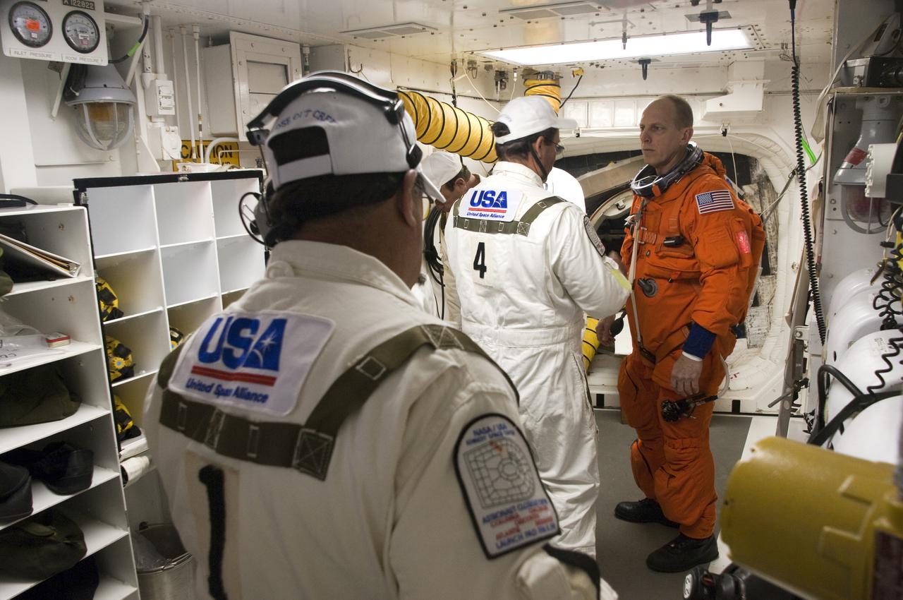 CAPE CANAVERAL, Fla. - At Launch Pad 39A at NASA's Kennedy Space Center in Florida, STS-131 Mission Specialist Clayton Anderson, at right, prepares to enter space shuttle Discovery from the pad's White Room.  The members of space shuttle Discovery's STS-131 crew, dressed in their launch-and-entry suits, are participating in the Terminal Countdown Demonstration Test, or TCDT, a dress rehearsal for launch.  TCDT includes training on the emergency exit systems at the launch pad, driving practice of the M-113 armored personnel carrier and a simulated launch countdown. The crew will deliver the multi-purpose logistics module Leonard, filled with resupply stowage platforms and science racks, to the International Space Station. STS-131, targeted for launch on April 5, will be the 33rd shuttle mission to the station and the 131st shuttle mission overall. For information on the STS-131 mission and crew, visit http:__www.nasa.gov_mission_pages_shuttle_shuttlemissions_sts131_index.htm. Photo credit: NASA_Regina Mitchell-Ryall