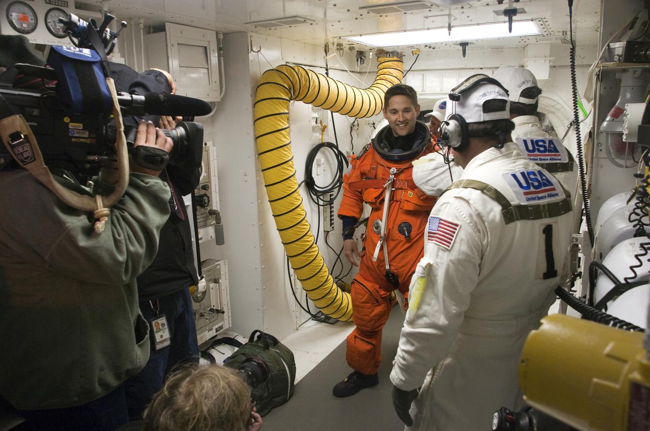 CAPE CANAVERAL, Fla. - At Launch Pad 39A at NASA's Kennedy Space Center in Florida, STS-131 Pilot James P. Dutton Jr., at left, prepares to enter space shuttle Discovery from the pad's White Room.  The members of space shuttle Discovery's STS-131 crew, dressed in their launch-and-entry suits, are participating in the Terminal Countdown Demonstration Test, or TCDT, a dress rehearsal for launch.  TCDT includes training on the emergency exit systems at the launch pad, driving practice of the M-113 armored personnel carrier and a simulated launch countdown. The crew will deliver the multi-purpose logistics module Leonard, filled with resupply stowage platforms and science racks, to the International Space Station. STS-131, targeted for launch on April 5, will be the 33rd shuttle mission to the station and the 131st shuttle mission overall. For information on the STS-131 mission and crew, visit http:__www.nasa.gov_mission_pages_shuttle_shuttlemissions_sts131_index.htm. Photo credit: NASA_Regina Mitchell-Ryall