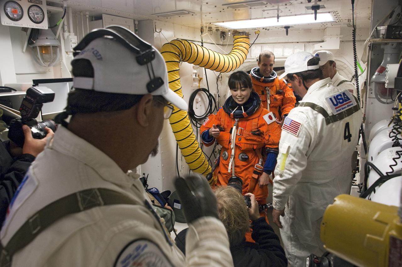 CAPE CANAVERAL, Fla. - At Launch Pad 39A at NASA's Kennedy Space Center in Florida, STS-131 Mission Specialists Naoko Yamazaki of the Japan Aerospace Exploration Agency and Rick Mastracchio, in the orange suits, prepare to enter space shuttle Discovery from the pad's White Room. The members of space shuttle Discovery's STS-131 crew, dressed in their launch-and-entry suits, are participating in the Terminal Countdown Demonstration Test, or TCDT, a dress rehearsal for launch. TCDT includes training on the emergency exit systems at the launch pad, driving practice of the M-113 armored personnel carrier and a simulated launch countdown. The crew will deliver the multi-purpose logistics module Leonard, filled with resupply stowage platforms and science racks, to the International Space Station. STS-131, targeted for launch on April 5, will be the 33rd shuttle mission to the station and the 131st shuttle mission overall. For information on the STS-131 mission and crew, visit http:__www.nasa.gov_mission_pages_shuttle_shuttlemissions_sts131_index.htm. Photo credit: NASA_Regina Mitchell-Ryall