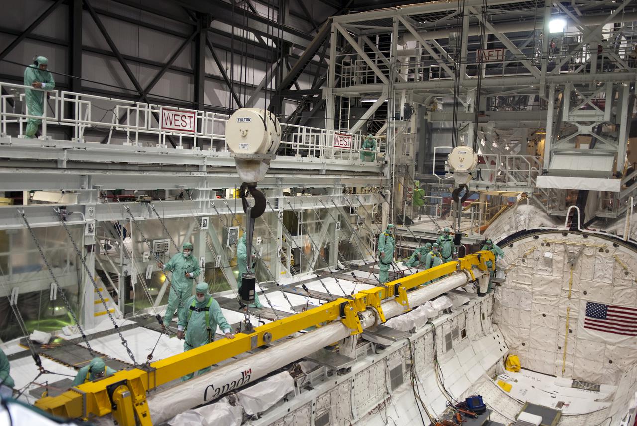 CAPE CANAVERAL, Fla. - Inside Orbiter Processing Facility-2 at Kennedy Space Center in Florida, technicians begin to detach the Orbiter Boom Sensor System, or OBSS, from the payload bay of space shuttle Endeavour. The OBSS will be transported to the Vehicle Assembly Building for refurbishment. After refurbishment, the boom will be reinstalled in Endeavour for use during the STS-134 mission, currently targeted for launch in July.  Photo credit: NASA_Jim Grossmann