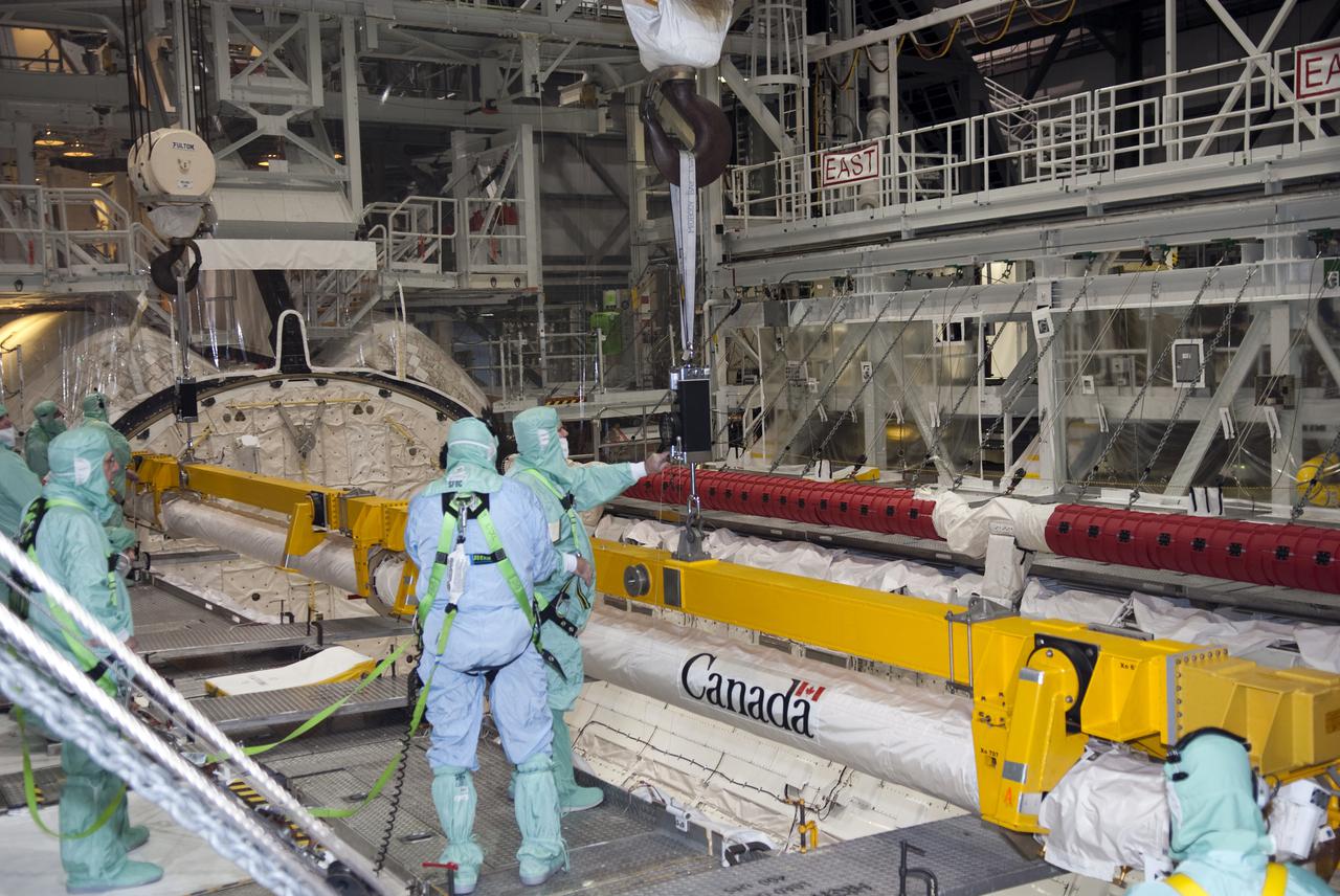 CAPE CANAVERAL, Fla. - Inside Orbiter Processing Facility-2 at Kennedy Space Center in Florida, technicians detach the Orbiter Boom Sensor System, or OBSS, from the payload bay of space shuttle Endeavour. The OBSS will be transported to the Vehicle Assembly Building for refurbishment. After refurbishment, the boom will be reinstalled in Endeavour for use during the STS-134 mission, currently targeted for launch in July.  Photo credit: NASA_Jim Grossmann