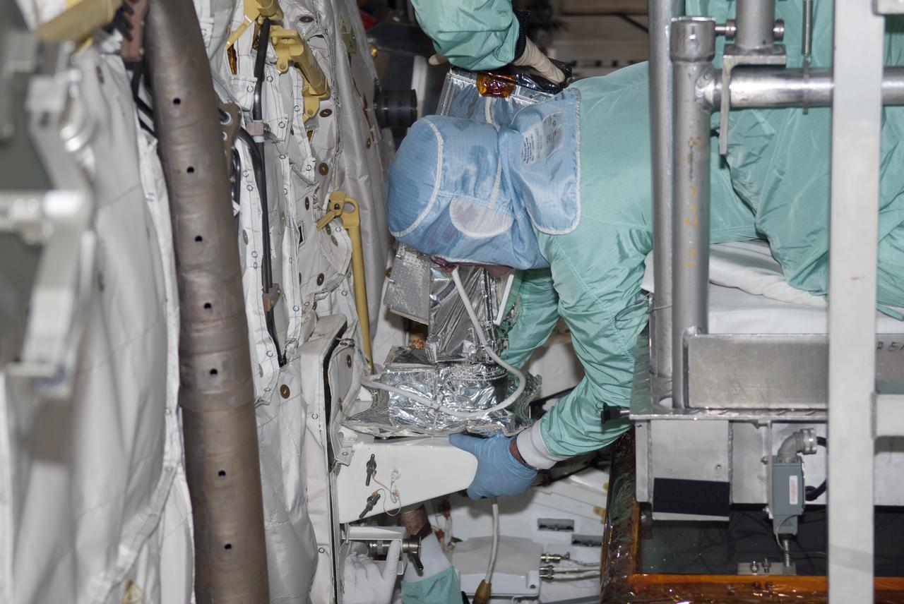CAPE CANAVERAL, Fla. - Inside Orbiter Processing Facility-1 at Kennedy Space Center in Florida, a technician dressed in a clean room suit, prepares to install a camera in the forward mid-body of shuttle Atlantis. Atlantis is being processed for the STS-132 mission targeted for launch May 14. The six-member crew will deliver an Integrated Cargo Carrier and a Russian-built Mini Research Module to the International Space Station. Photo credit: NASA_Jim Grossmann