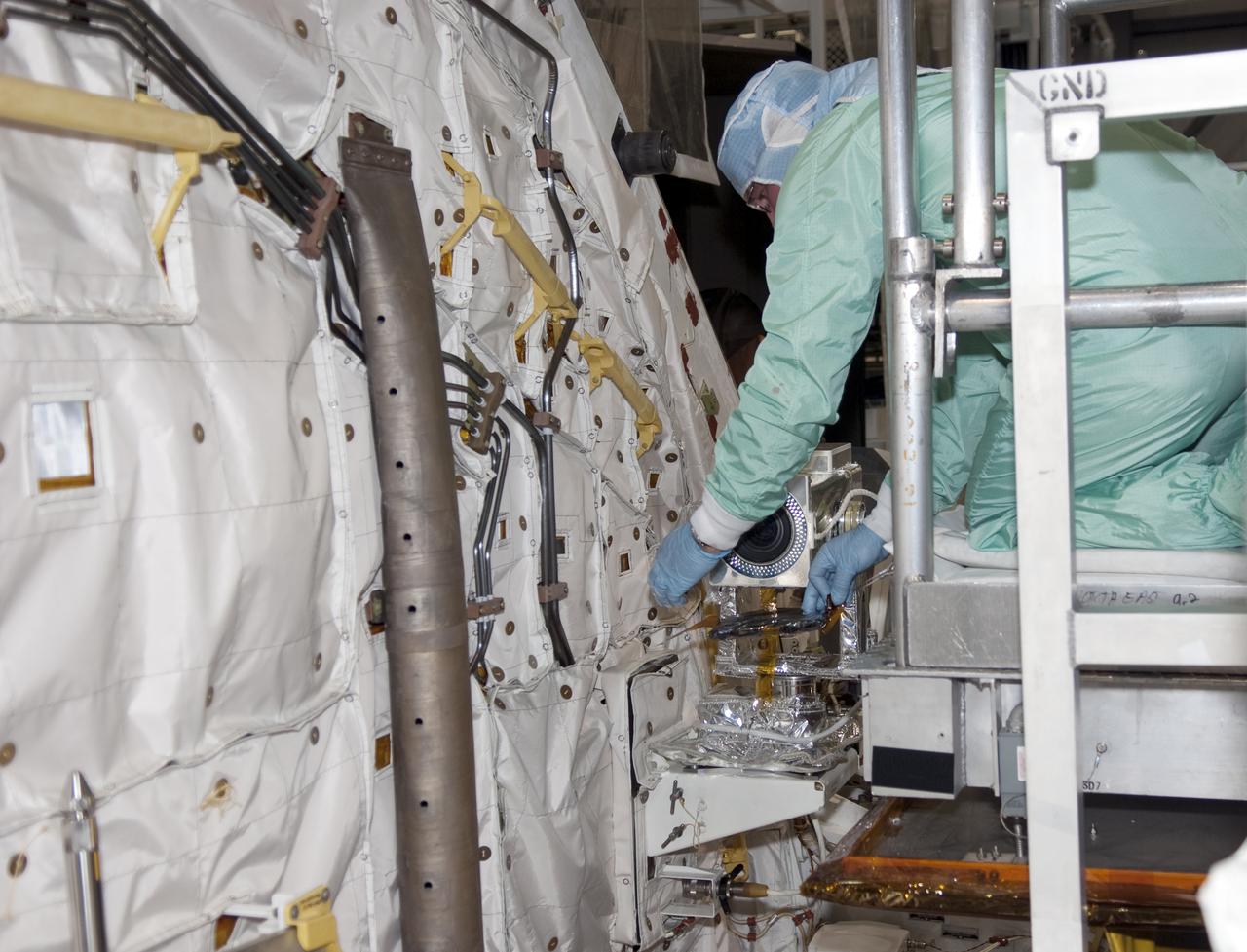 CAPE CANAVERAL, Fla. - Inside Orbiter Processing Facility-1 at Kennedy Space Center in Florida, a technician dressed in a clean room suit, installs a camera in the forward mid-body of shuttle Atlantis. Atlantis is being processed for the STS-132 mission targeted for launch May 14. The six-member crew will deliver an Integrated Cargo Carrier and a Russian-built Mini Research Module to the International Space Station. Photo credit: NASA_Jim Grossmann