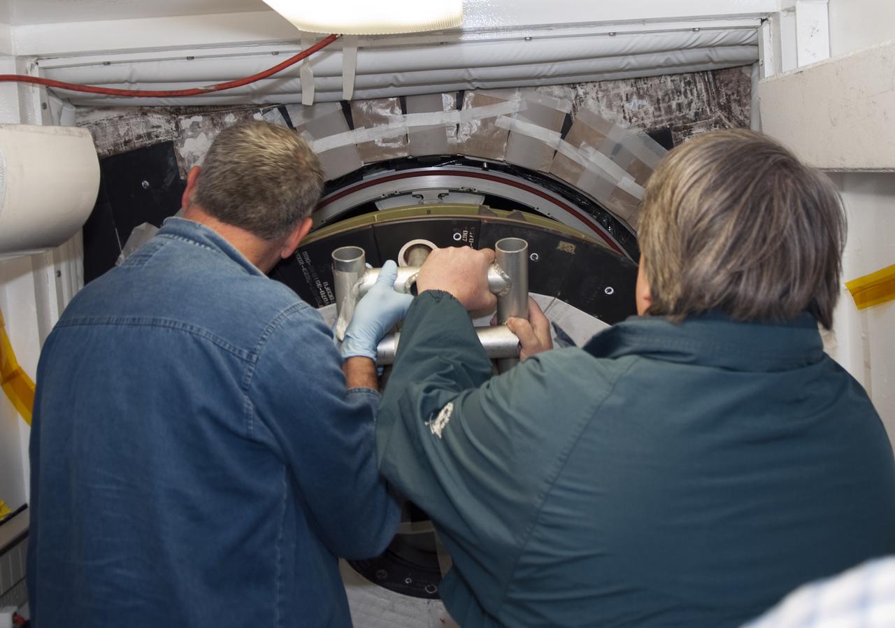 CAPE CANAVERAL, Fla. - Inside Orbiter Processing Facility-1 at Kennedy Space Center in Florida, technicians close shuttle Atlantis’ hatch in preparation for the Mylar Pull Test. During the test, the hatch is closed and a scale is used to measure the force required to pull a piece of Mylar paper out from between the door and structural wall thermal barriers. The pull test is performed to ensure the integrity of the hatch and that it has closed properly. Atlantis is being processed for the STS-132 mission targeted for launch May 14. The six-member crew will deliver an Integrated Cargo Carrier and a Russian-built Mini Research Module to the International Space Station. Photo credit: NASA_Jim Grossmann