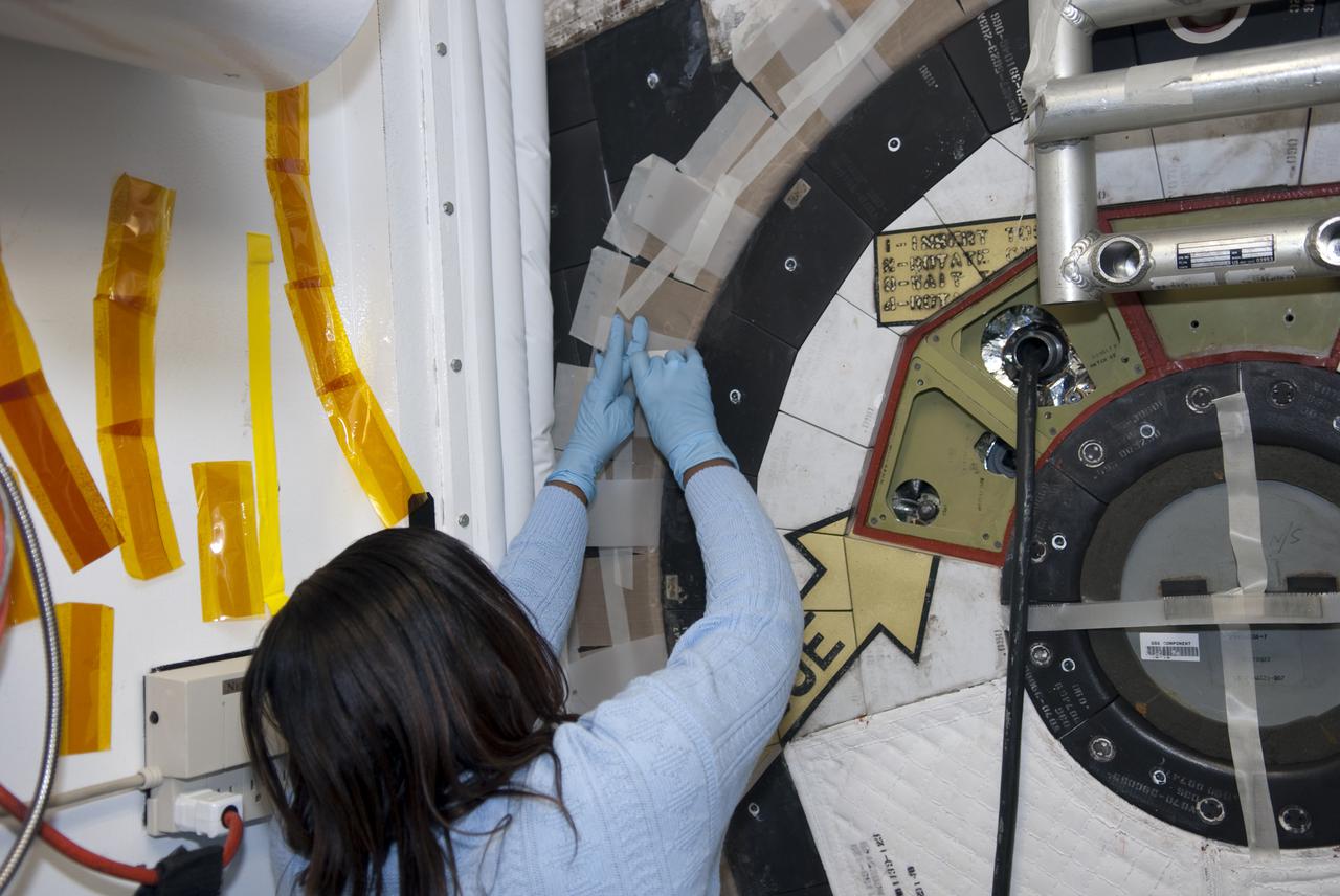 CAPE CANAVERAL, Fla. - Inside Orbiter Processing Facility-1 at Kennedy Space Center in Florida, a technician secures shuttle Atlantis’ hatch in preparation for the Mylar Pull Test. During the test, a scale is used to measure the force required to pull a piece of Mylar paper out from between the door and structural wall thermal barriers. The pull test is performed to ensure the integrity of the hatch and that it has closed properly. Atlantis is being processed for the STS-132 mission targeted for launch May 14. The six-member crew will deliver an Integrated Cargo Carrier and a Russian-built Mini Research Module to the International Space Station. Photo credit: NASA_Jim Grossmann