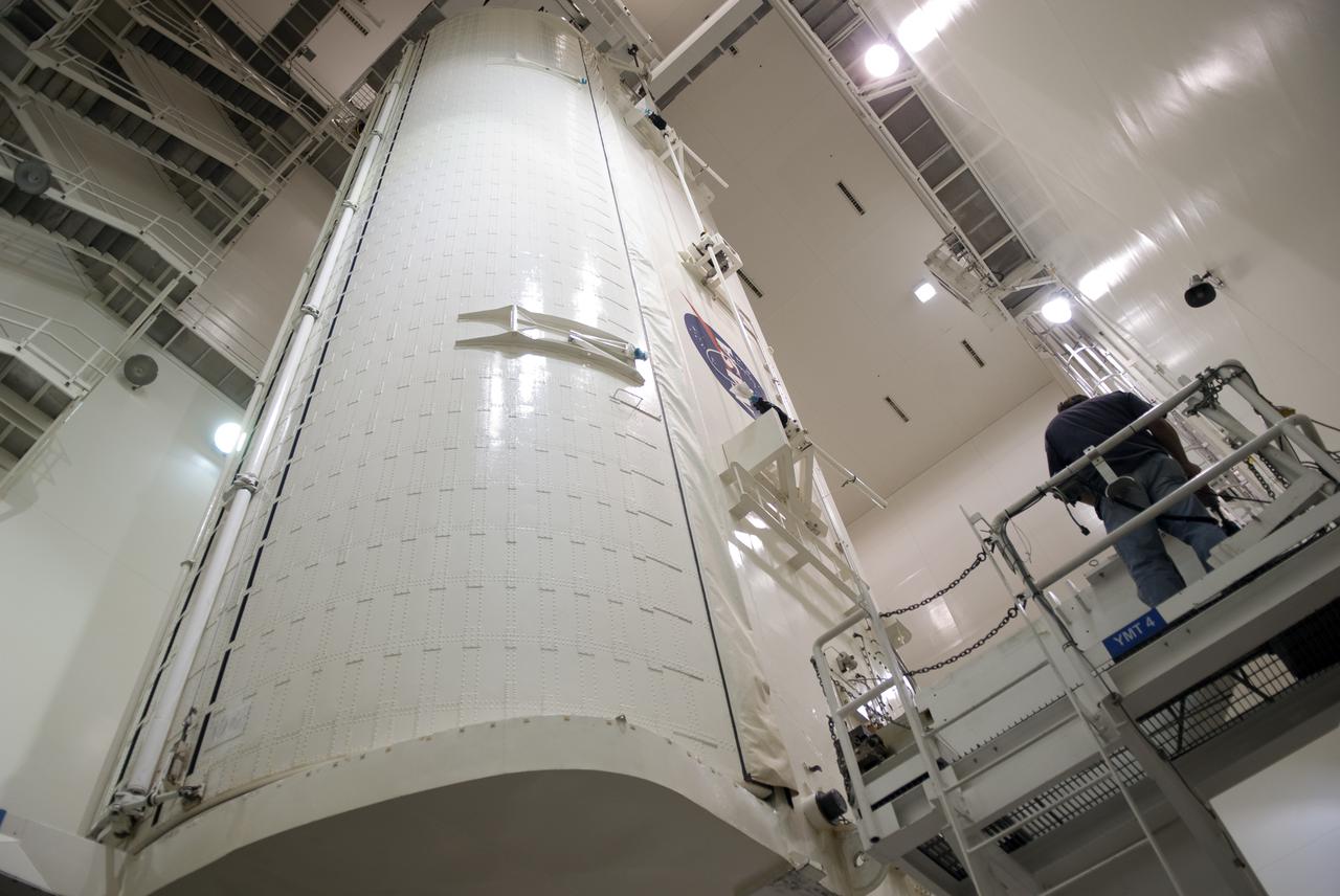 CAPE CANAVERAL, Fla. - In the Canister Rotation Facility at NASA's Kennedy Space Center in Florida, the payload canister containing the multi-purpose logistics module Leonardo, rotated into a vertical position, is lowered onto its transporter.  Leonardo will be transported to Launch Pad 39A and installed into space shuttle Discovery for its upcoming flight.  The seven-member STS-131 crew will deliver Leonardo, filled with resupply stowage platforms and racks, to the International Space Station.  STS-131 will be the 33rd shuttle mission to the station and the 131st shuttle mission overall. Launch is targeted for April 5.  For information on the STS-131 mission and crew, visit http:__www.nasa.gov_mission_pages_shuttle_shuttlemissions_sts131_index.html.  Photo credit: NASA_Jim Grossmann