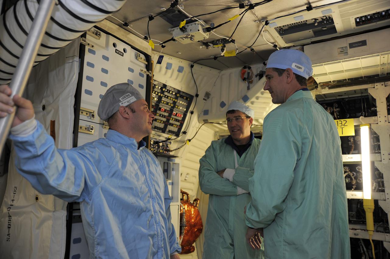 CAPE CANAVERAL, Fla. – In Orbiter Processing Facility-1 at NASA's Kennedy Space Center in Florida, members of space shuttle Atlantis' STS-132 crew participate in training activities during the Crew Equipment Interface Test, or CEIT, for their mission. Here, from left, Mission Specialists Garrett Reisman, Steve Bowen and Michael Good take the opportunity to compare notes in Atlantis' middeck.  They are dressed in clean room attire, known as bunny suits.  CEIT provides the crew with hands-on training and observation of shuttle and flight hardware.  The six-member crew of Atlantis' STS-132 mission will deliver an Integrated Cargo Carrier and the Russian-built Mini-Research Module-1 to the International Space Station.  STS-132 is the 34th mission to the station and the 132nd space shuttle mission.   Launch is targeted for May 14.  For information on the STS-132 mission, visit http:__www.nasa.gov_mission_pages_shuttle_shuttlemissions_sts132_index.html. Photo credit: NASA_Kim Shiflett