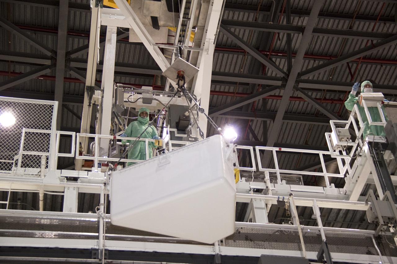 CAPE CANAVERAL, Fla. – In Orbiter Processing Facility-1 at NASA's Kennedy Space Center in Florida, workers dressed in clean room attire, known as bunny suits, monitor the lift by jib crane of the tool stowage assembly.  The tool box is being installed into space shuttle Atlantis' payload bay.  The assembly contains tools and hardware that will be needed on the extravehicular activities, or spacewalks, conducted during the STS-132 mission. On STS-132, the six-member crew will deliver an Integrated Cargo Carrier and a Russian-built Mini-Research Module to the International Space Station.  STS-132 is the 34th mission to the station and the 132nd space shuttle mission.   Launch is targeted for May 14.  For information on the STS-132 mission, visit http:__www.nasa.gov_mission_pages_shuttle_shuttlemissions_sts132_index.html. Photo credit: NASA_Jack Pfaller