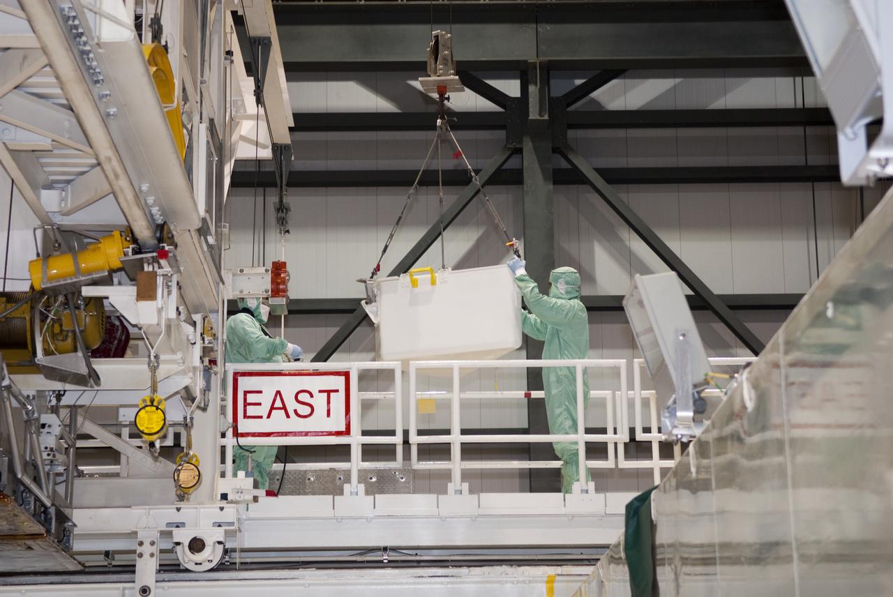 CAPE CANAVERAL, Fla. – In Orbiter Processing Facility-1 at NASA's Kennedy Space Center in Florida, workers dressed in clean room attire, known as bunny suits, carefully guide the tool stowage assembly across the work platform on which they are standing.  The tool box is being installed into space shuttle Atlantis' payload bay.  The assembly contains tools and hardware that will be needed on the extravehicular activities, or spacewalks, conducted during the STS-132 mission. On STS-132, the six-member crew will deliver an Integrated Cargo Carrier and a Russian-built Mini-Research Module to the International Space Station.  STS-132 is the 34th mission to the station and the 132nd space shuttle mission.   Launch is targeted for May 14.  For information on the STS-132 mission, visit http:__www.nasa.gov_mission_pages_shuttle_shuttlemissions_sts132_index.html. Photo credit: NASA_Jim Grossmann