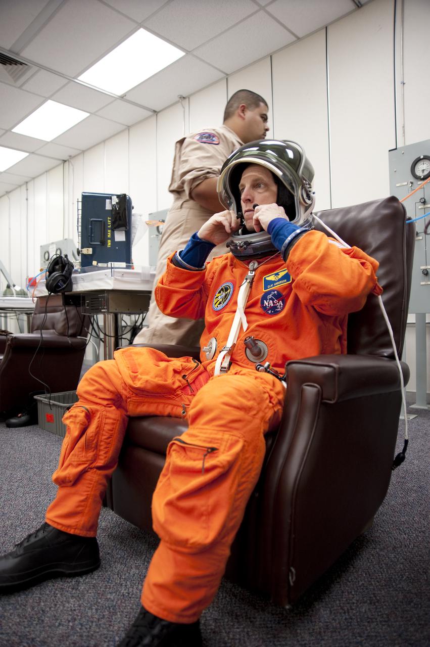 CAPE CANAVERAL, Fla. - In the Operations and Checkout Building at NASA's Kennedy Space Center in Florida, the astronauts of space shuttle Discovery's STS-131 crew put on their launch-and-entry suits before heading to the Astrovan for the ride to Launch Pad 39A. Mission Specialist Clayton Anderson, seen here, checks the fit of his suit's helmet.  Liftoff of the STS-131 mission is set for 6:21 a.m. EDT on April 5. On STS-131, the seven-member crew will deliver the multi-purpose logistics module Leonardo, filled with supplies, a new crew sleeping quarters and science racks that will be transferred to the International Space Station's laboratories.  The crew also will switch out a gyroscope on the station’s truss, install a spare ammonia storage tank and retrieve a Japanese experiment from the station’s exterior.  STS-131 is the 33rd shuttle mission to the station and the 131st shuttle mission overall. For information on the STS-131 mission and crew, visit http:__www.nasa.gov_mission_pages_shuttle_shuttlemissions_sts131_index.html.  Photo credit: NASA_Kim Shiflett