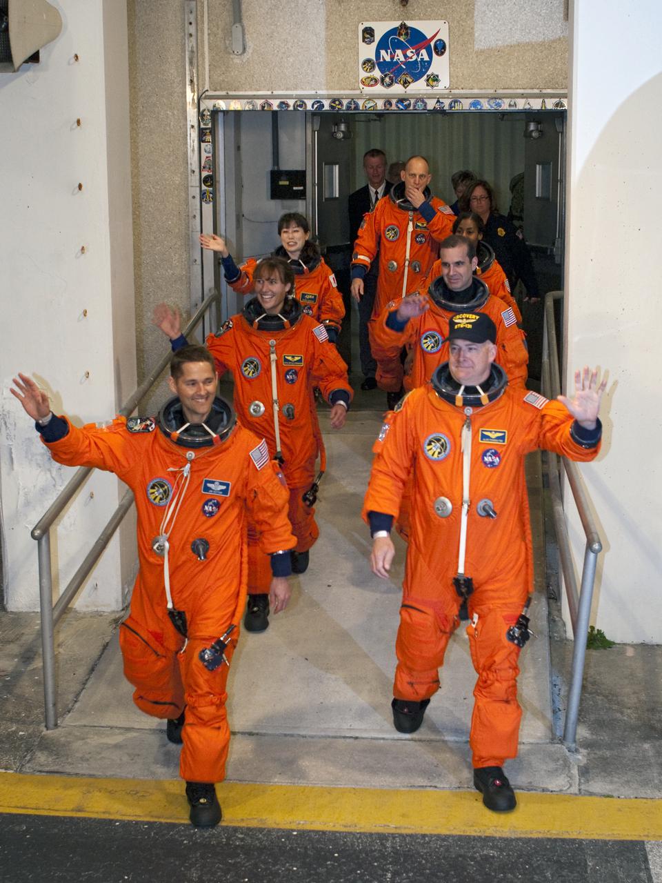 CAPE CANAVERAL, Fla. - At NASA's Kennedy Space Center in Florida, the astronauts on space shuttle Discovery's STS-131 crew, dressed in their orange launch-and-entry suits, wave to spectators as they walk out of the Operations and Checkout Building for the ride in the Astrovan to Launch Pad 39A.  In the left column, from the front, are Pilot James P. Dutton Jr. and Mission Specialists Dorothy Metcalf-Lindenburger and Naoko Yamazaki of the Japan Aerospace Exploration Agency.  In the right column, from the front, are Commander Alan Poindexter and Mission Specialists Rick Mastracchio and Stephanie Wilson.  Mission Specialist Clayton Anderson is in the back.  Liftoff of the STS-131 mission is set for 6:21 a.m. EDT on April 5. On STS-131, the seven-member crew will deliver the multi-purpose logistics module Leonardo, filled with supplies, a new crew sleeping quarters and science racks that will be transferred to the International Space Station's laboratories.  The crew also will switch out a gyroscope on the station’s truss, install a spare ammonia storage tank and retrieve a Japanese experiment from the station’s exterior.  STS-131 is the 33rd shuttle mission to the station and the 131st shuttle mission overall. For information on the STS-131 mission and crew, visit http:__www.nasa.gov_mission_pages_shuttle_shuttlemissions_sts131_index.html.  Photo credit: NASA_Kim Shiflett